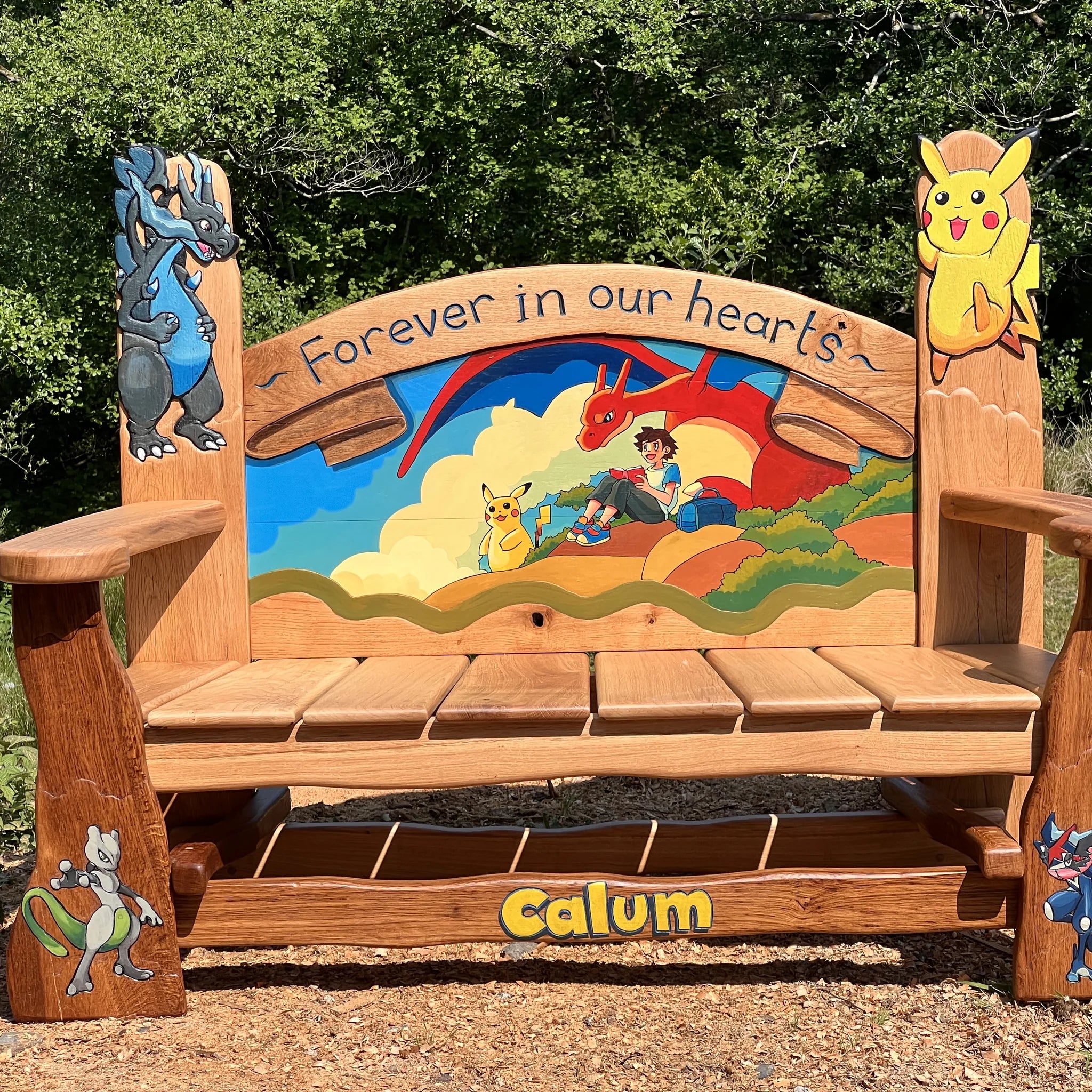 Hand-carved and painted oak children's memorial bench with a Pokémon scene and Forever in our hearts