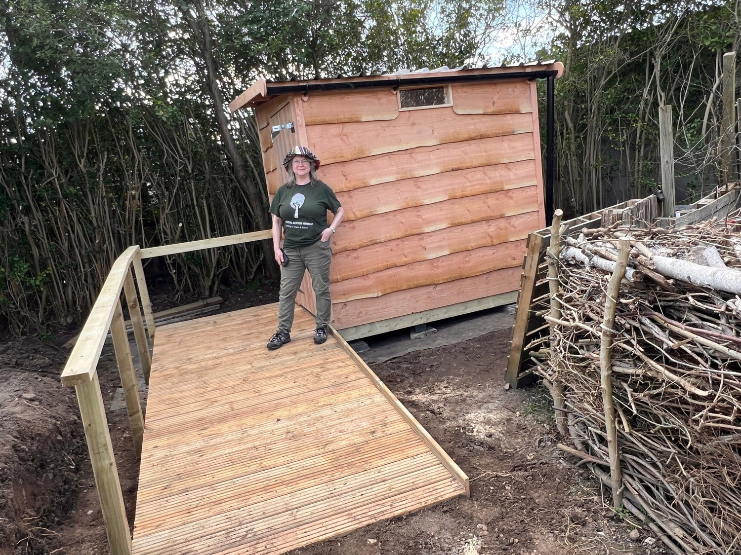 Wooden Compost Toilet building with wheelchair accessible ramp for Community Garden