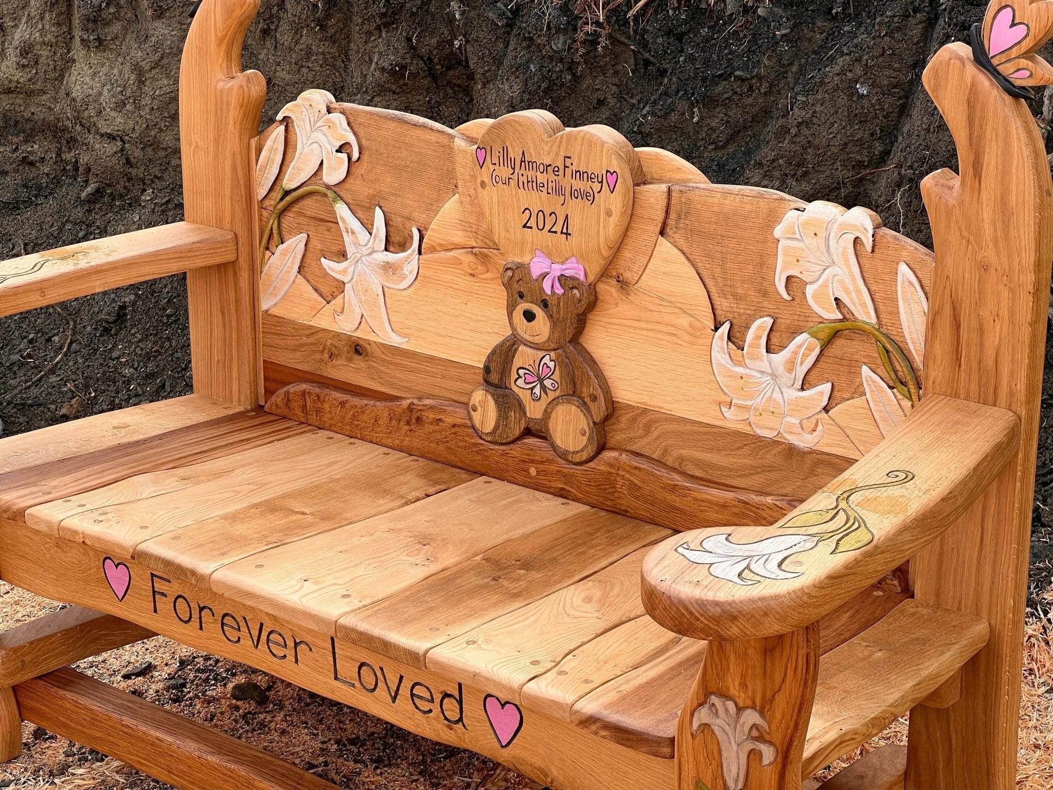 Handmade and personalised wooden memorial bench. Individual design with heart, teddy bear, butterflies and lily flowers