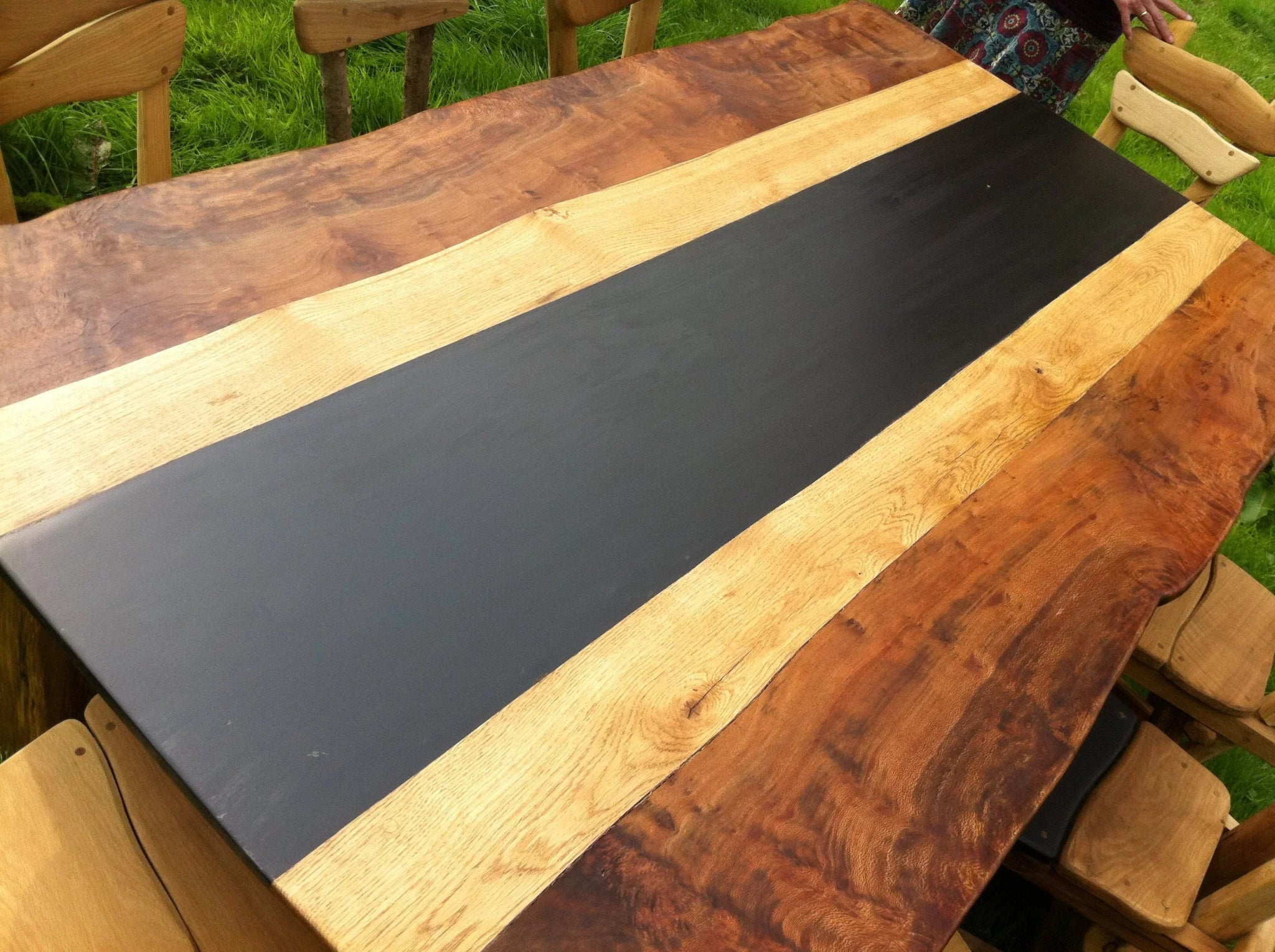 Rustic handcrafted wooden dining table with a striking live-edge design and contrasting inlay, showcasing artisanal craftsmanship and natural materials