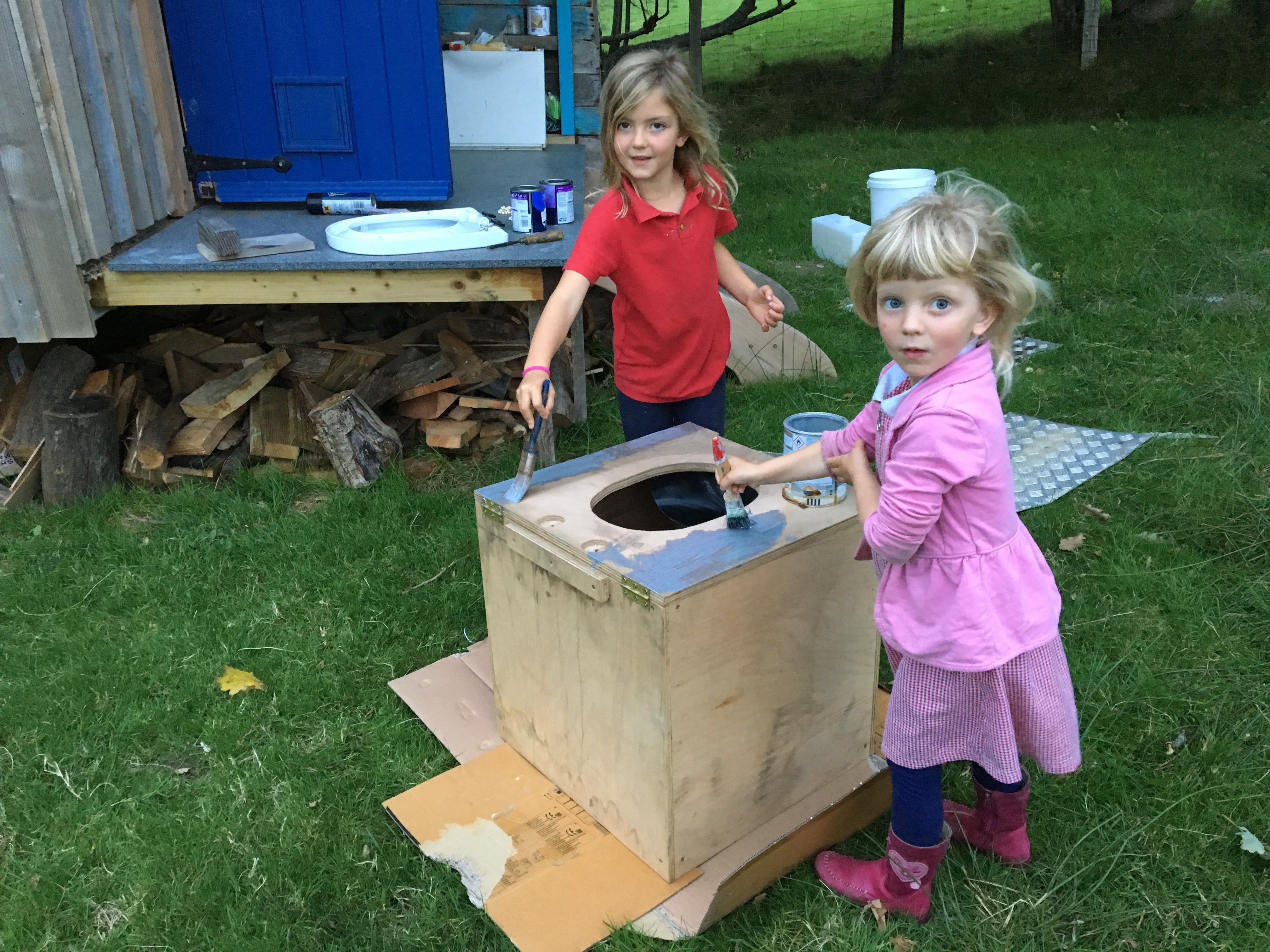 photo amusante de mes deux filles en train de peindre une boîte de toilettes à compost