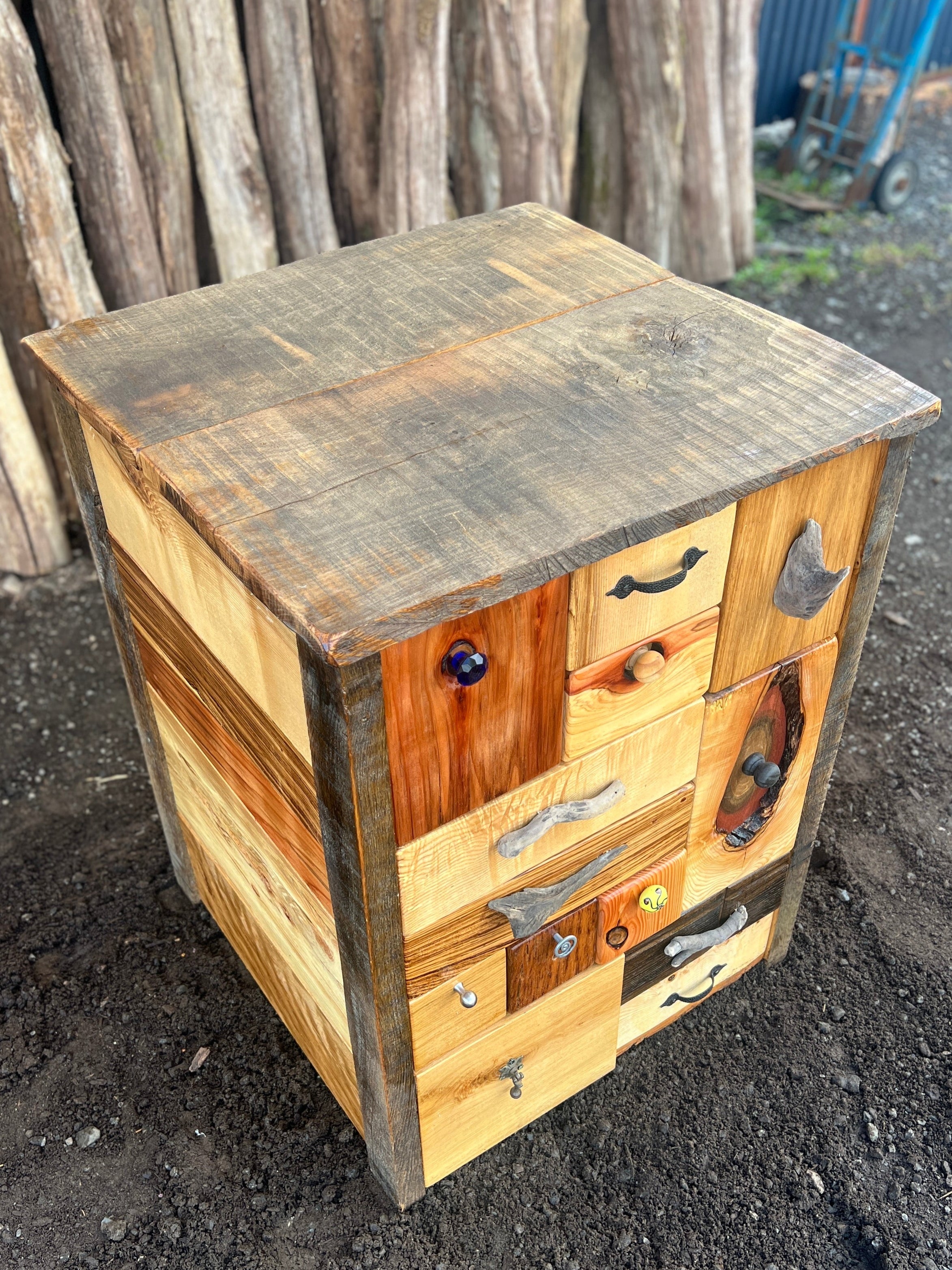 Left angle of rustic wooden chest showing unique drawer handles and reclaimed wood grains