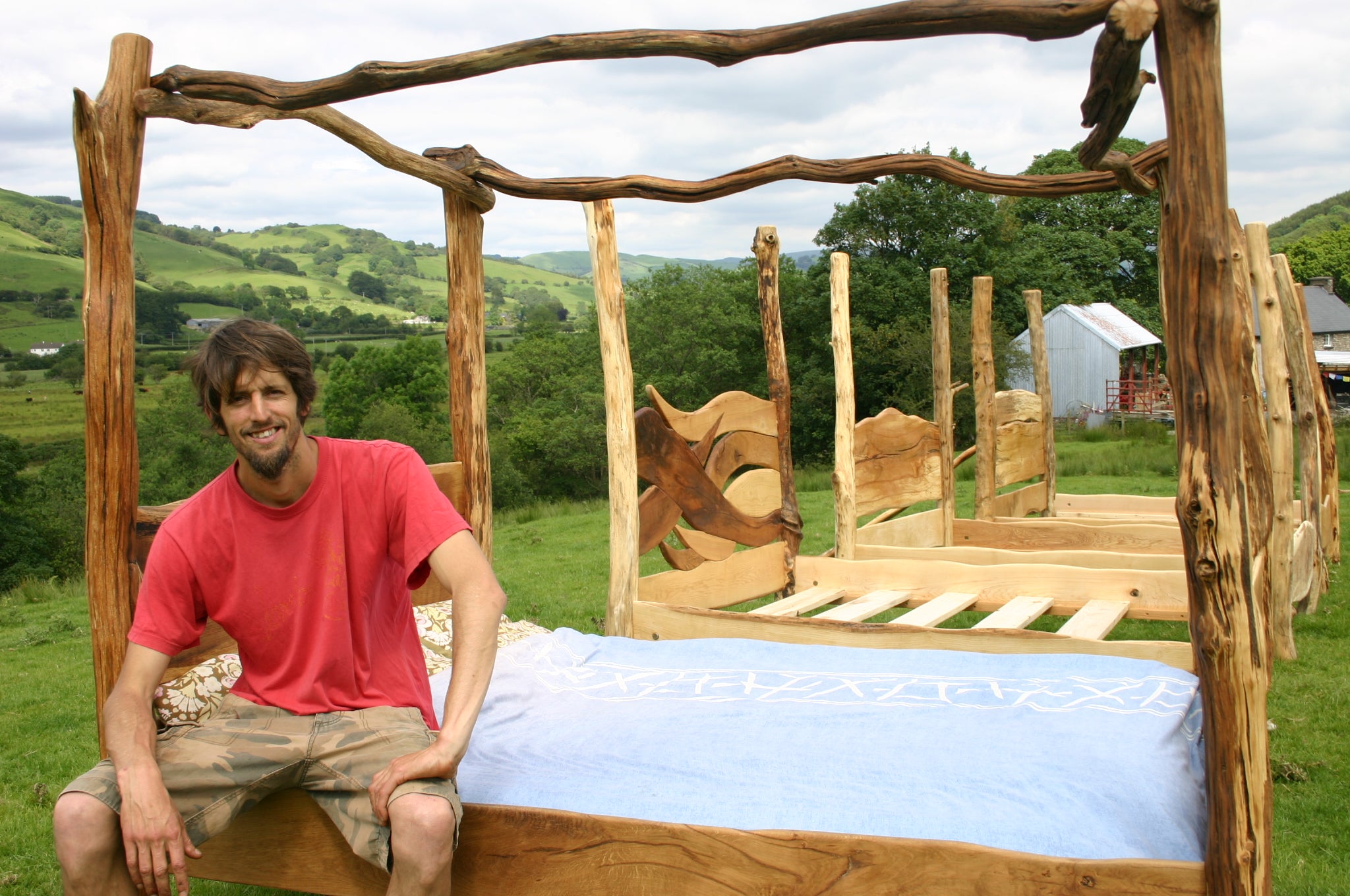 Paul Bullen in front of some of the four poster beds Free Range Designs makes in there workshops pictured behind