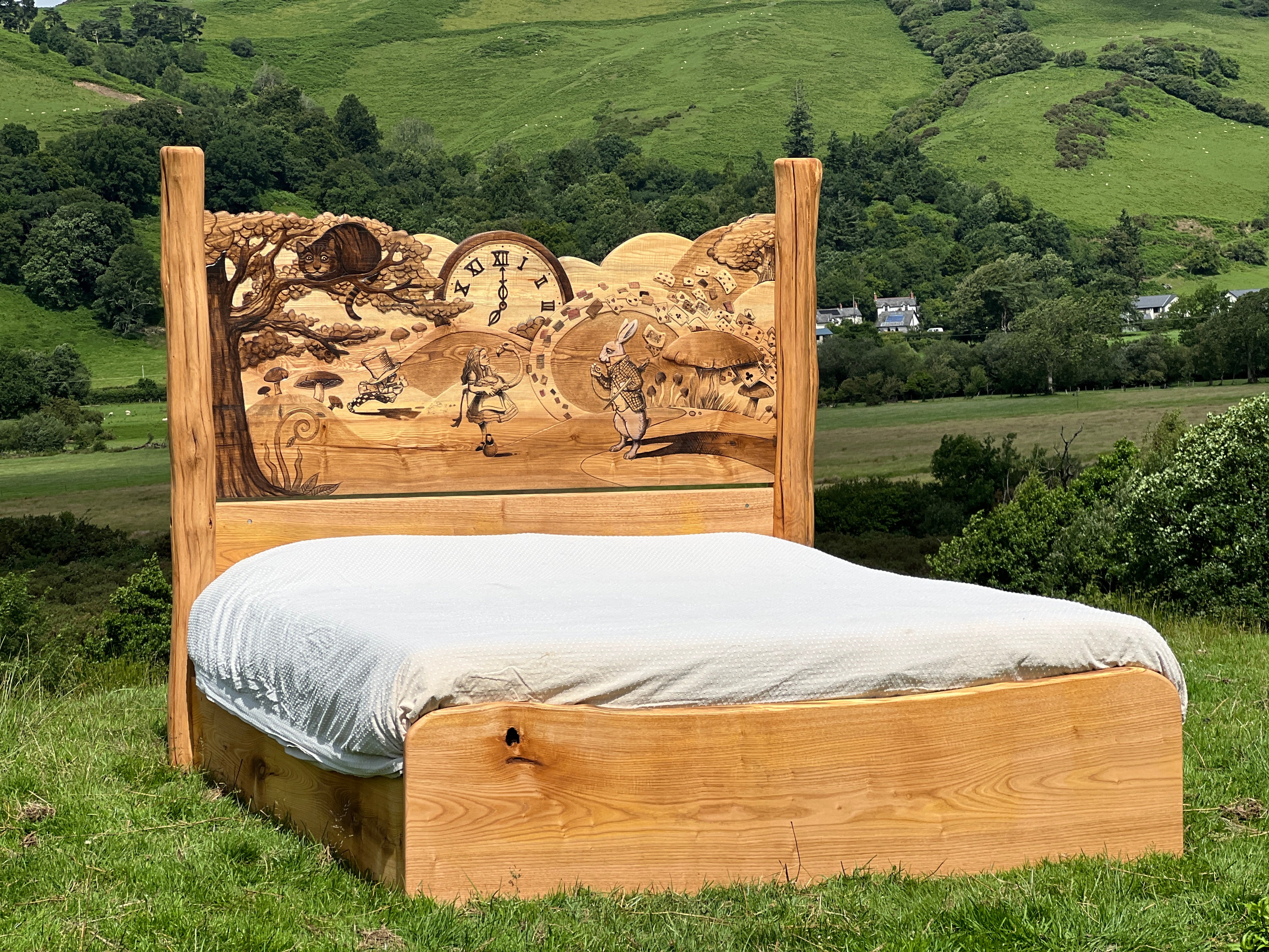 Side angle of handcrafted wooden bed showing engraved Alice in Wonderland characters