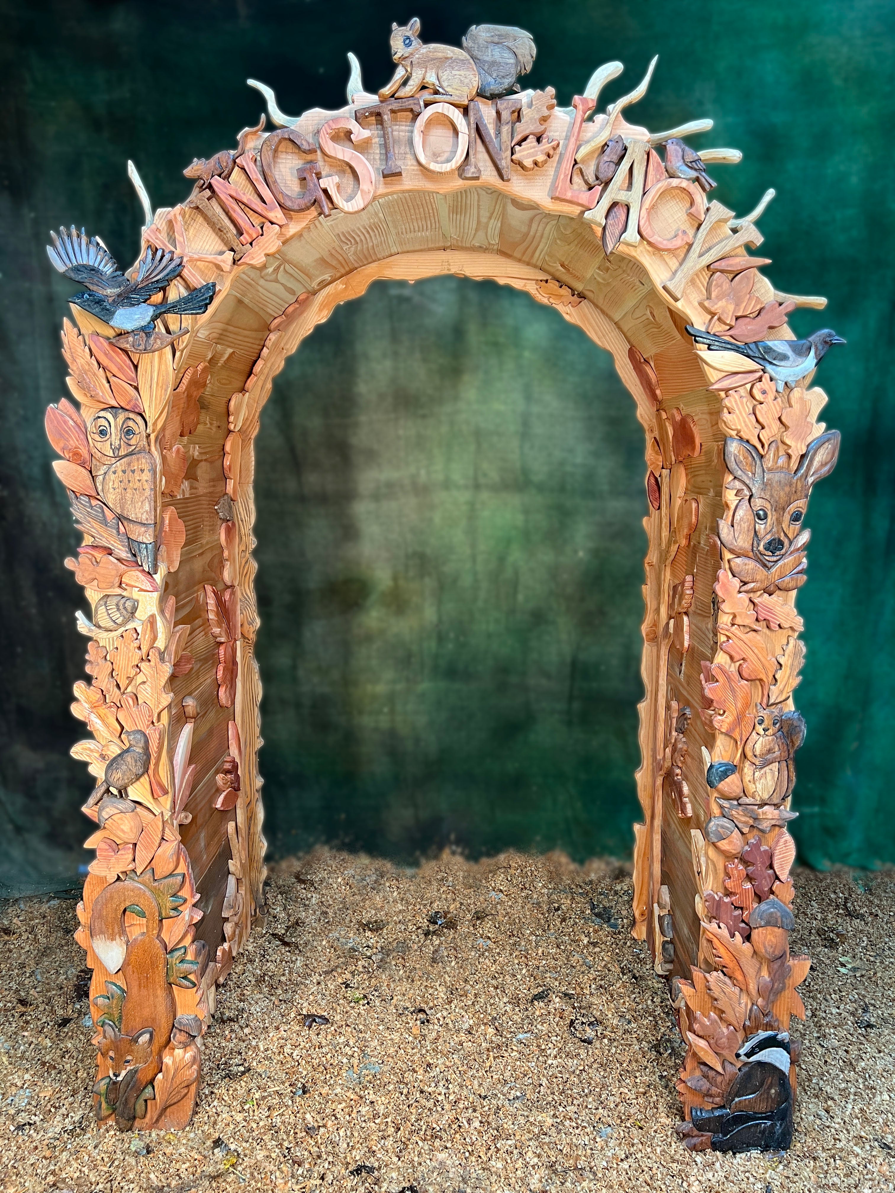 Decorative arch with animal figures and 'Jewelstone' text on a textured surface.