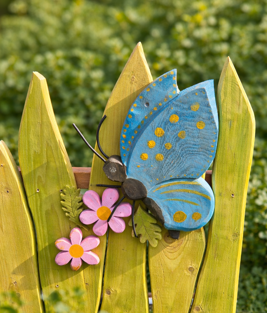 Decorative butterfly and flowers on a wooden fence with a blurred green background