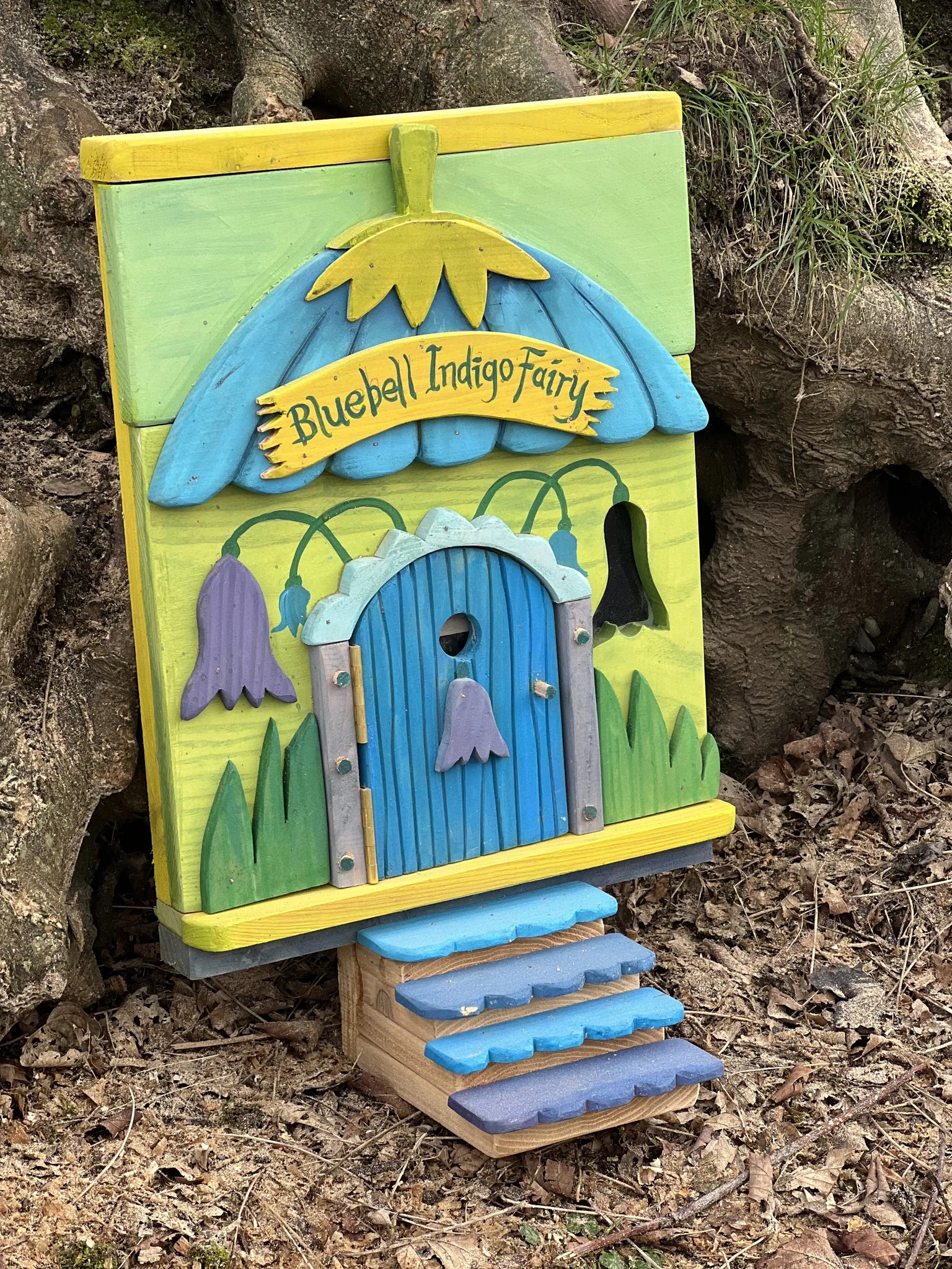 Side angle of bluebell fairy house showing deep indigo blue paintwork and hand-crafted wooden details