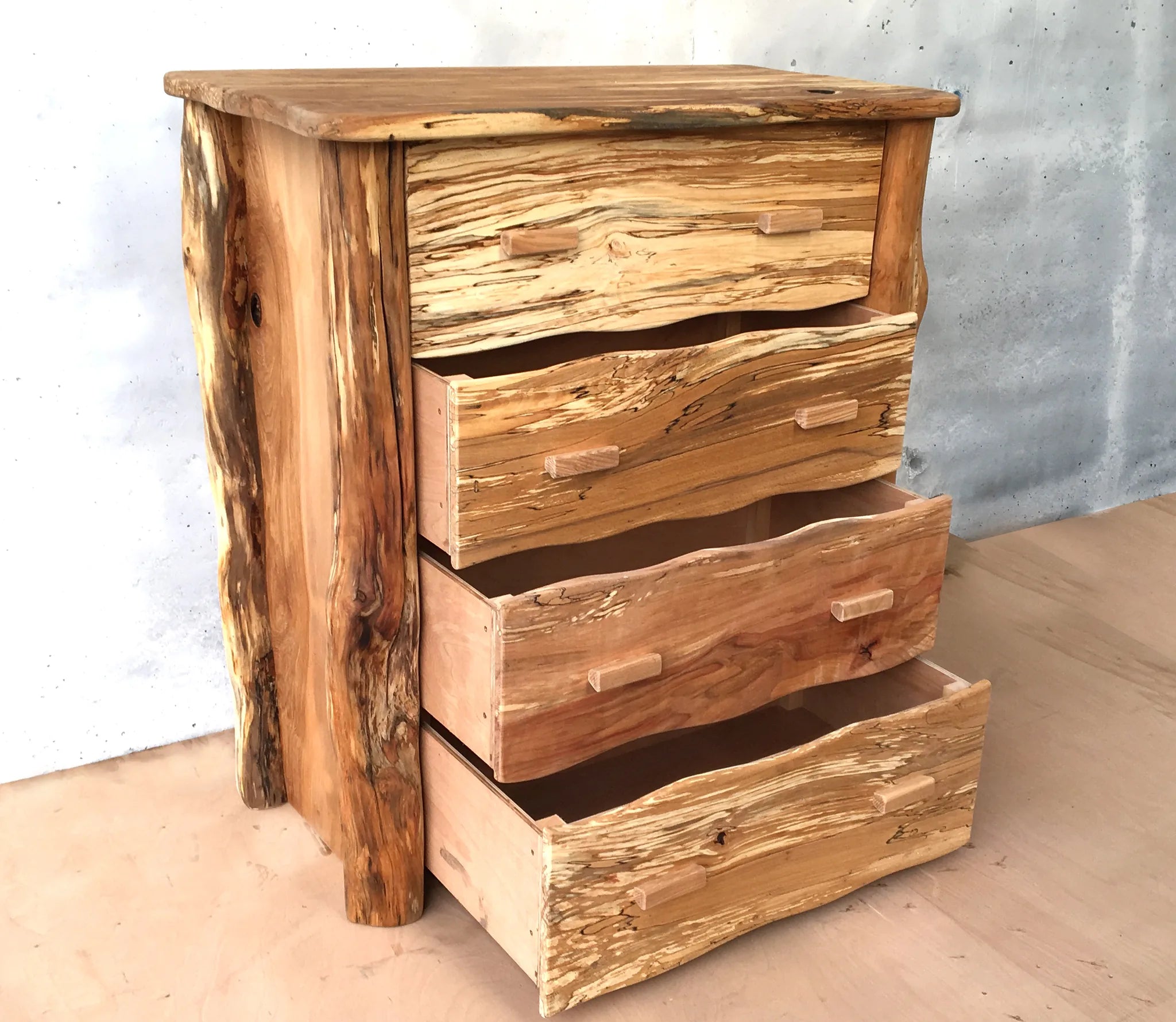 Rustic spalted beech chest of drawers at an angle with drawers open, natural live-edge timber and wooden handles
