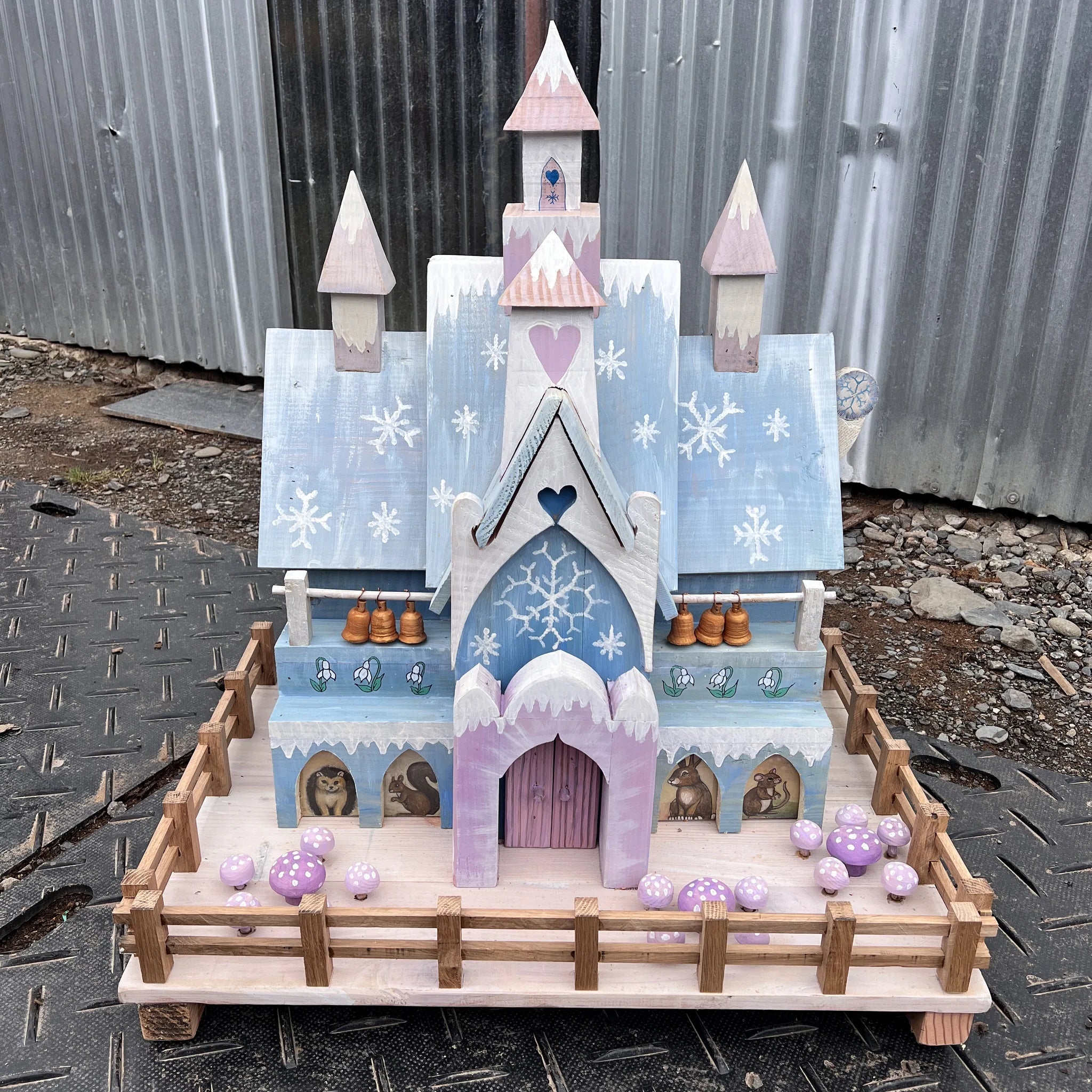 Handmade ice palace fairy house with frosted blue and white paintwork, snow-capped towers and snowflake door details