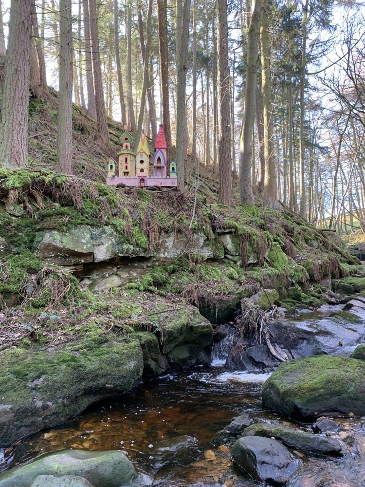 Village de fées sur une colline au bord d'un ruisseau