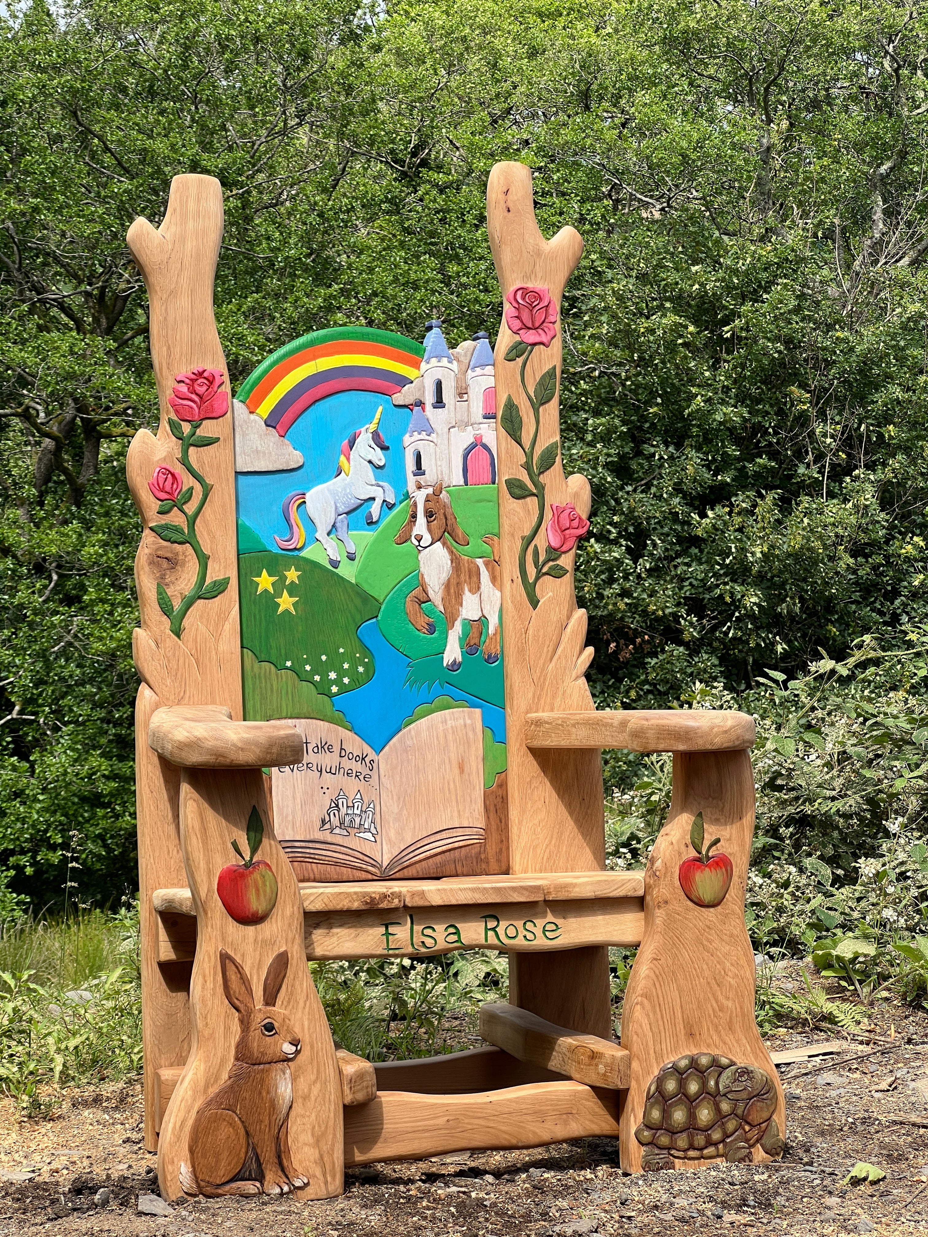Whimsical wooden storytelling chair featuring a dragon, castle, and frog carved into the backrest