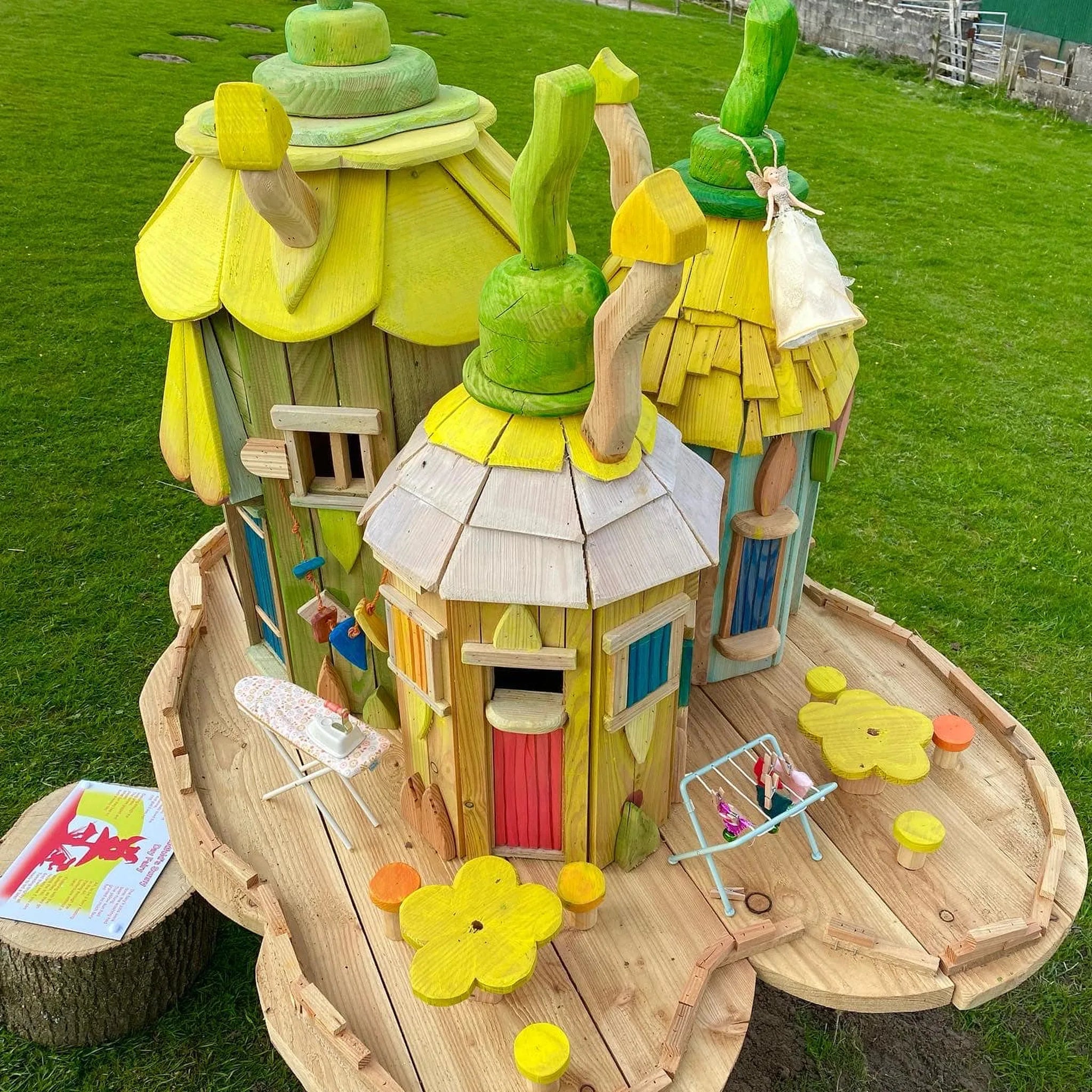 Handmade botanical flower village fairy house with hand-painted floral details across clustered buildings