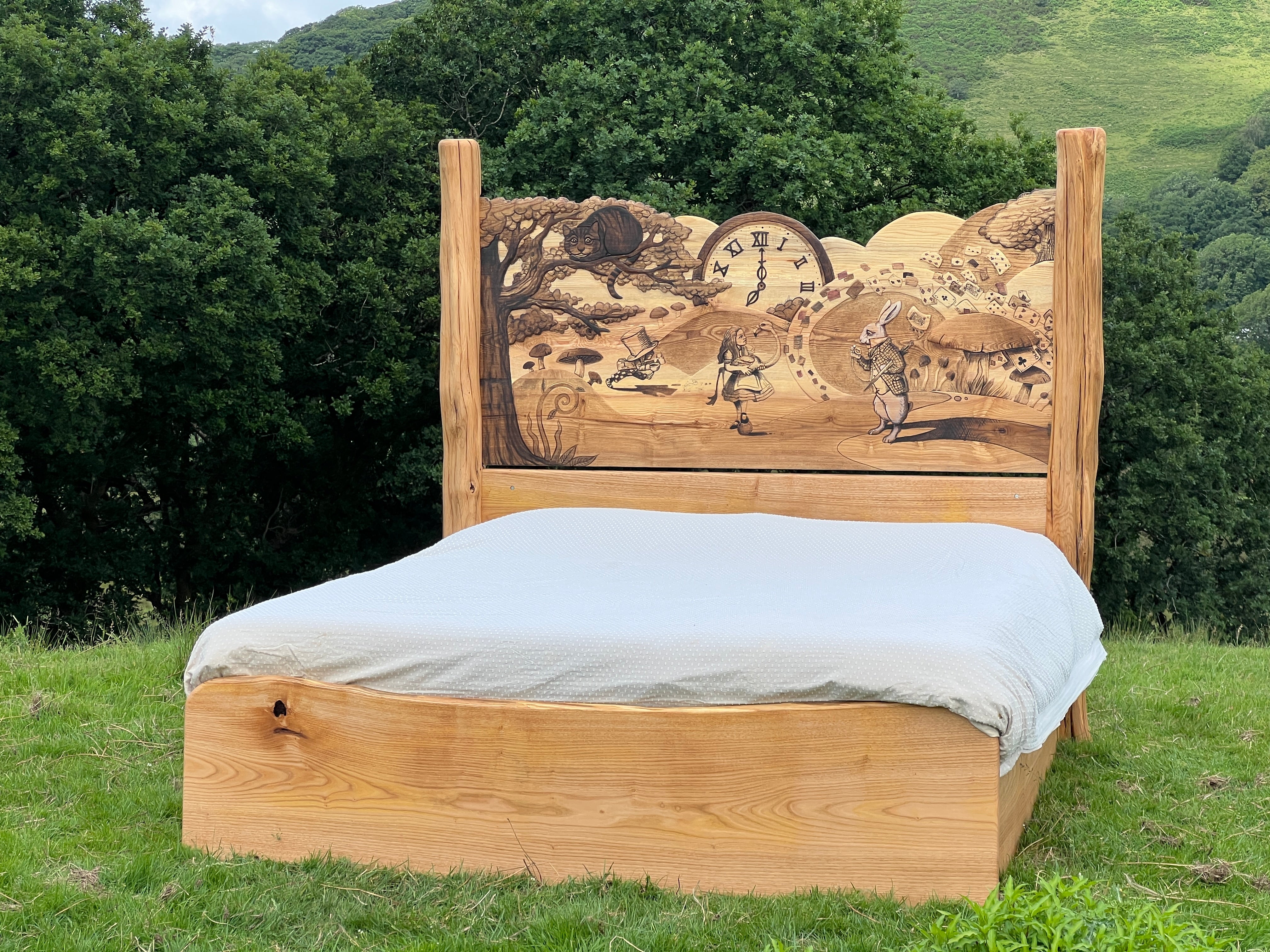 Handmade fantasy bed with Alice in Wonderland scene stained into natural wood headboard