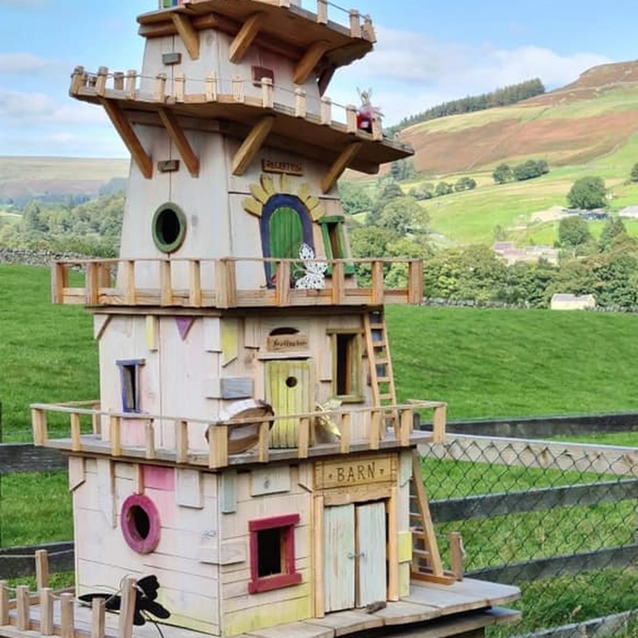 Handmade multi-storey helter skelter fairy village tower with fairground colours and spiral slide details