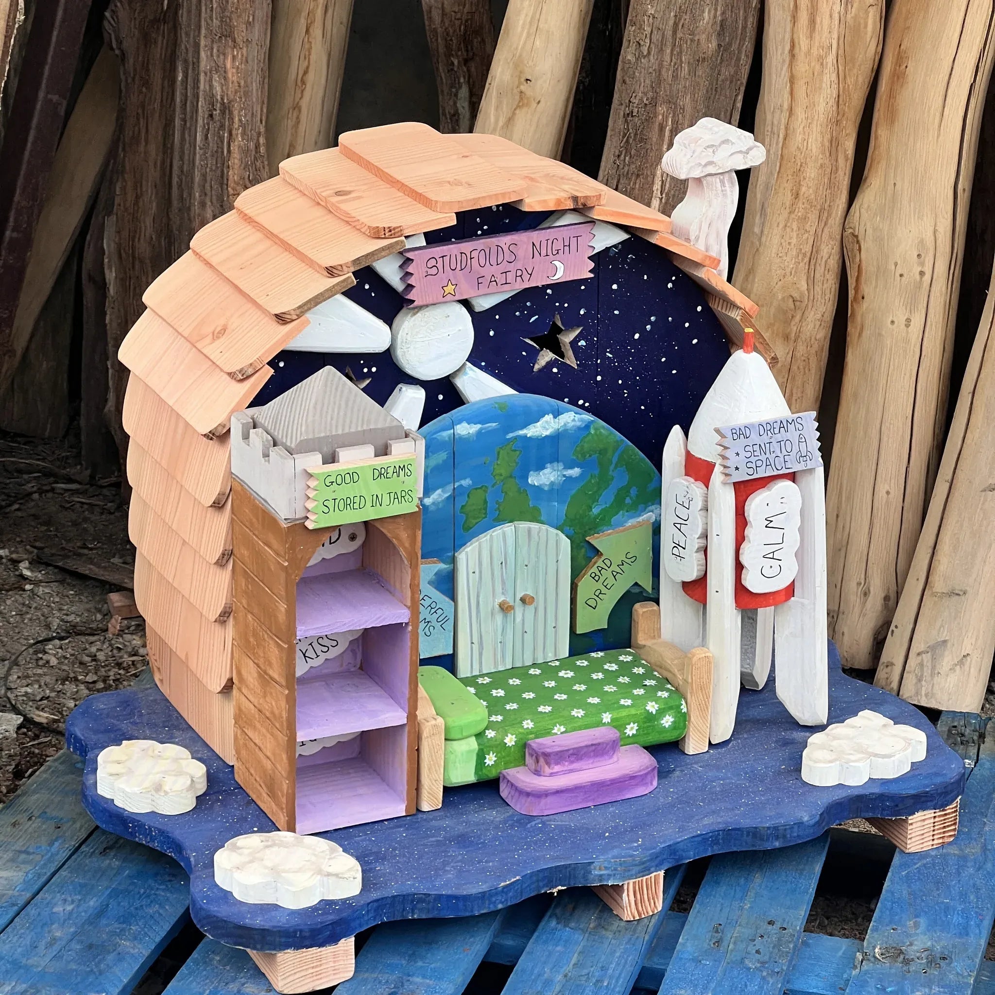 Handmade night fairy dream house with dark painted walls, star motifs and crescent moon window details