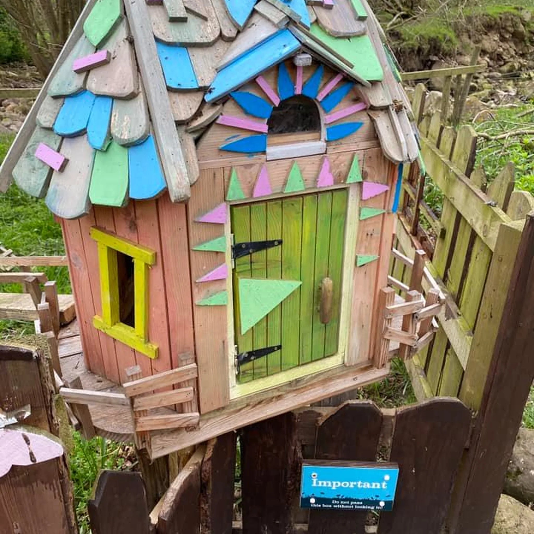 Handmade patchwork fairy cottage with colourful mosaic-effect painted roof and multi-hued decorated walls