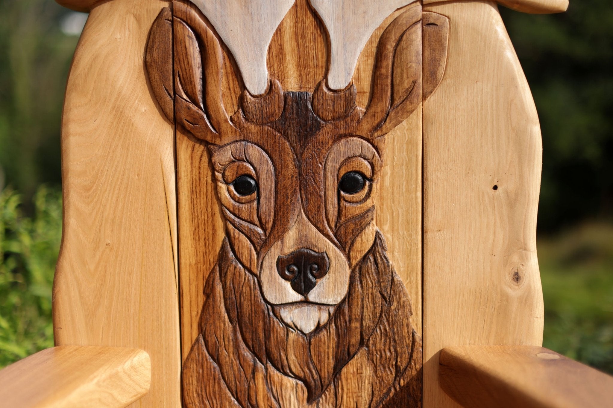 Wooden bench with a deer head carving in the backrest