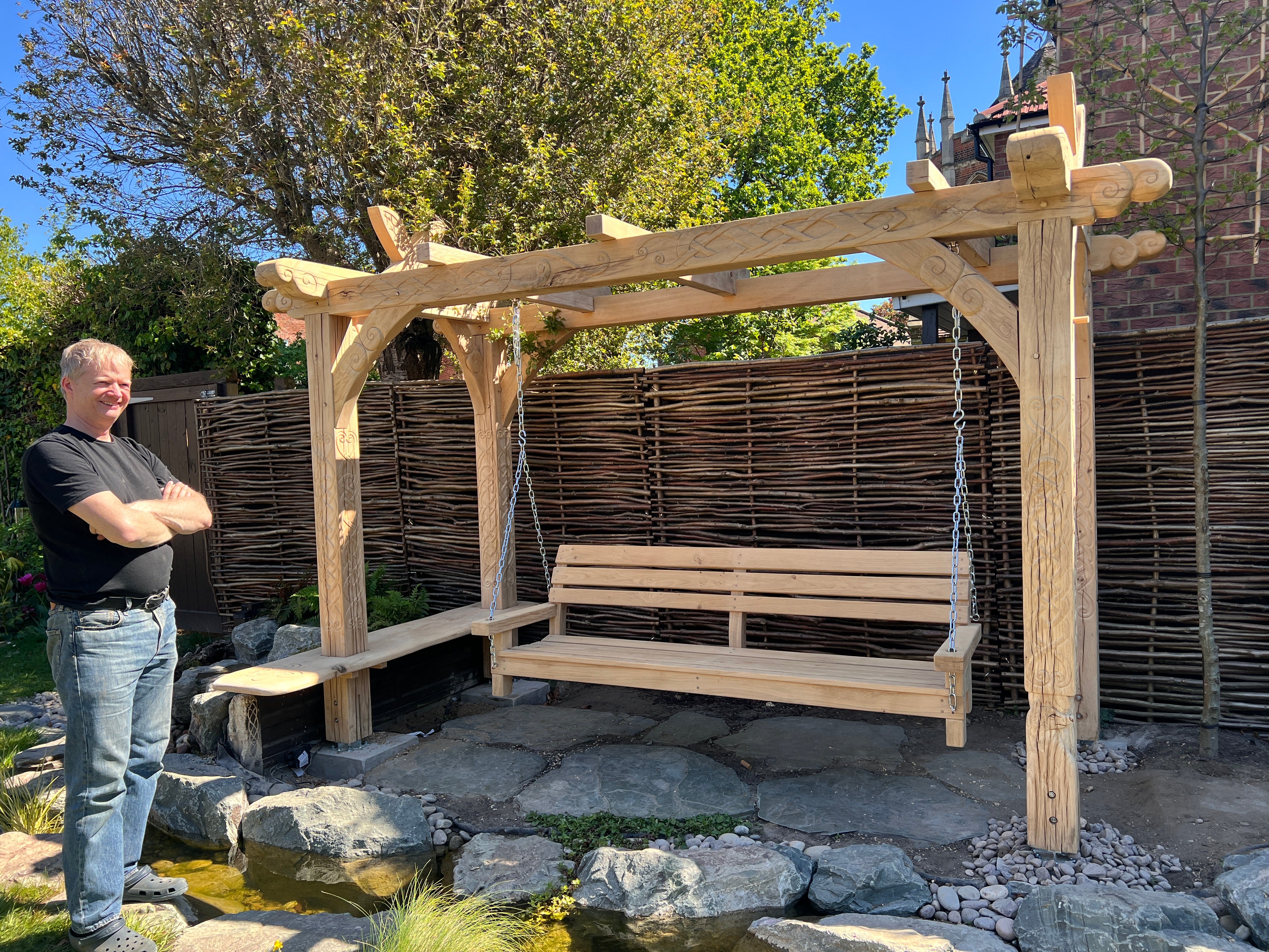 Viking knotwork and Celtic scroll carvings hand-carved into solid air-dried oak posts of the bespoke garden arbour