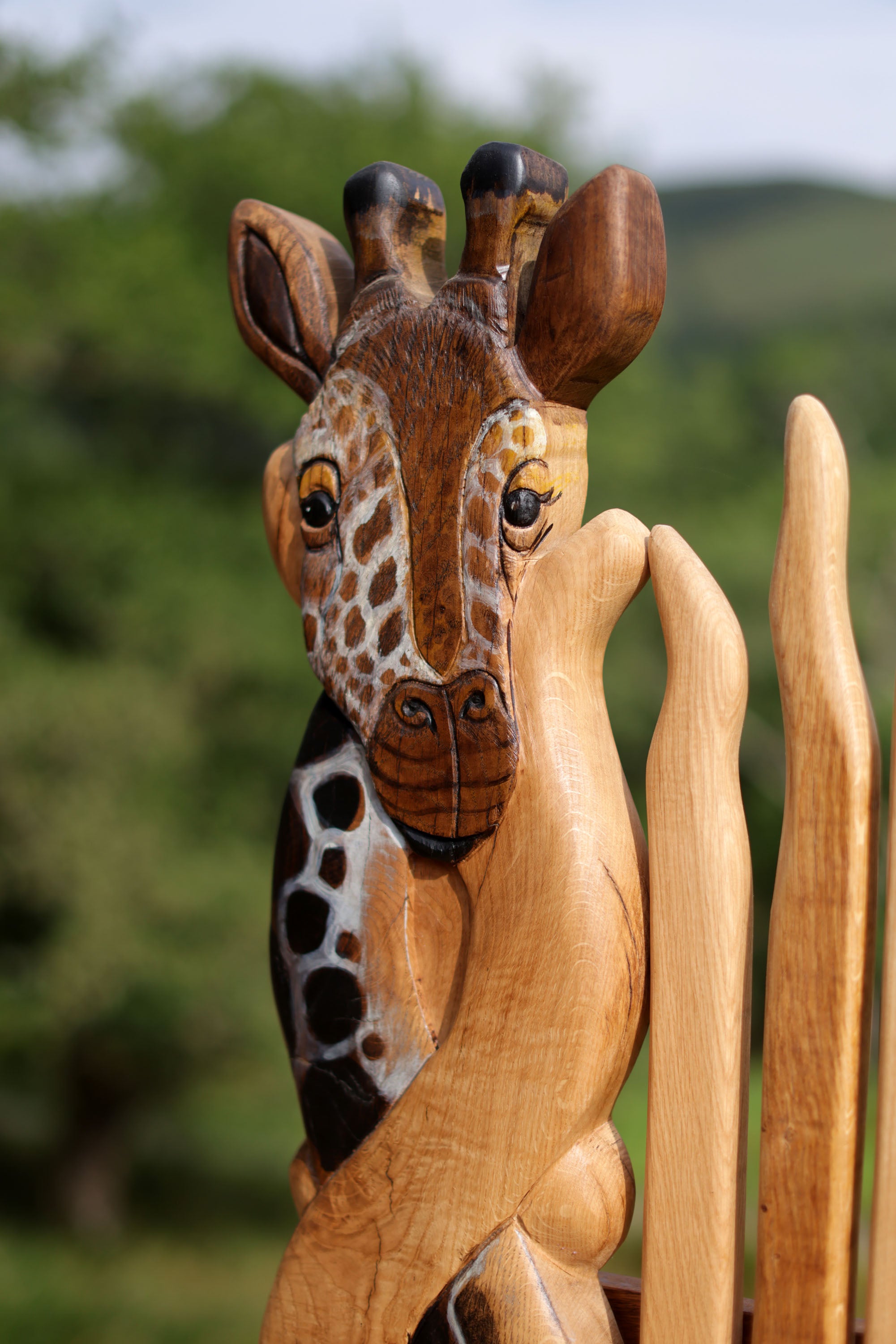 Wooden giraffe figurine with a blurred natural background