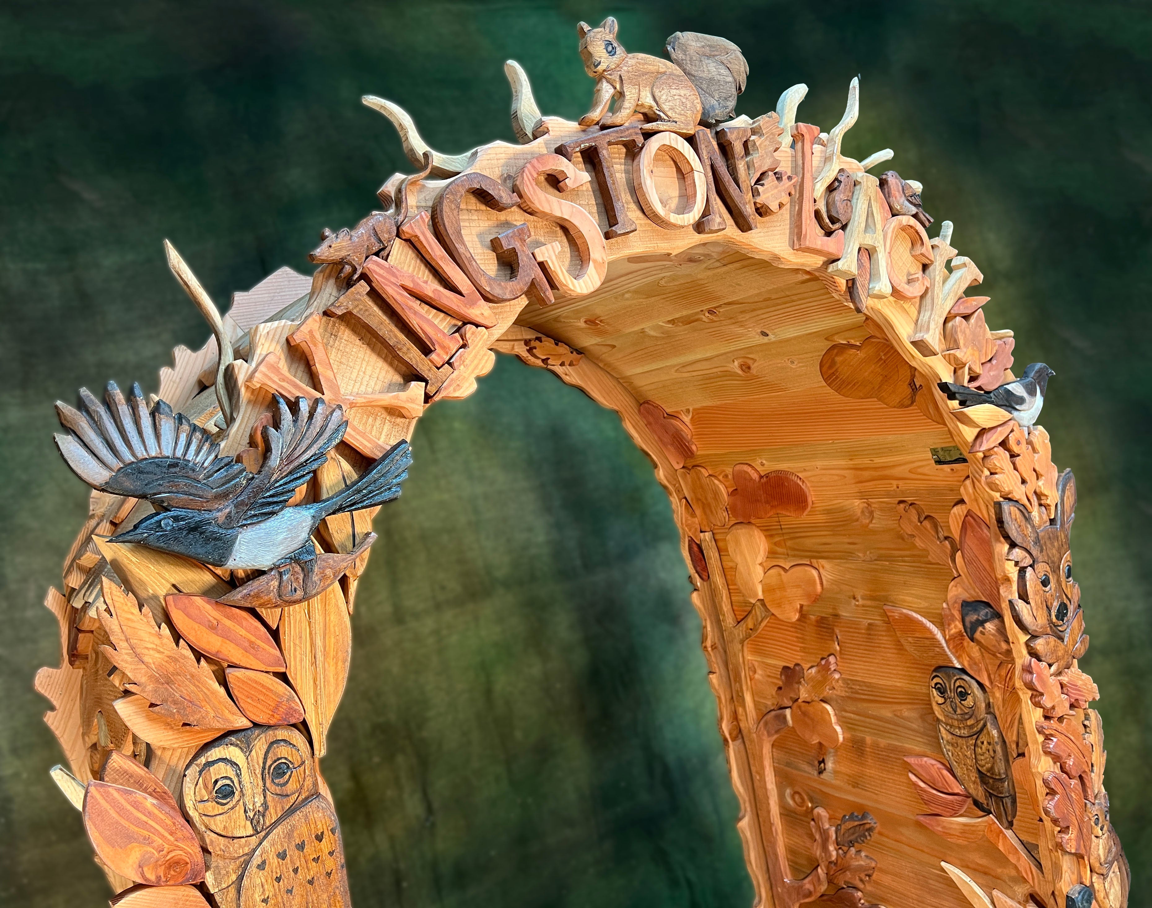 close up of woodland arch top showing carved birds squirrel leaves and kingston lacy lettering