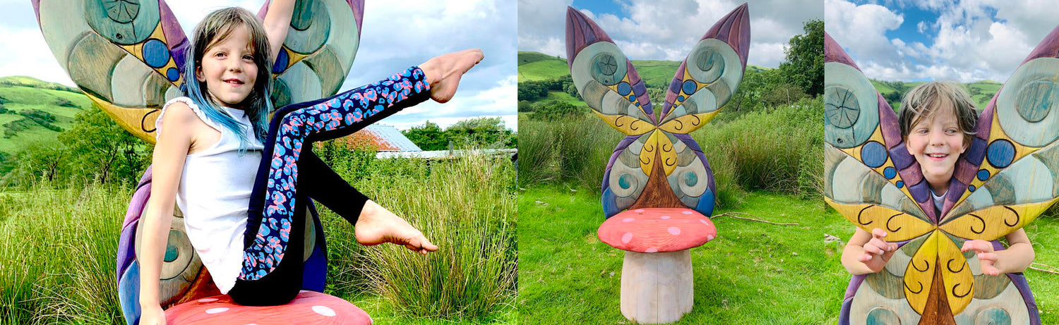 Child enjoying colorful butterfly-themed outdoor chair.