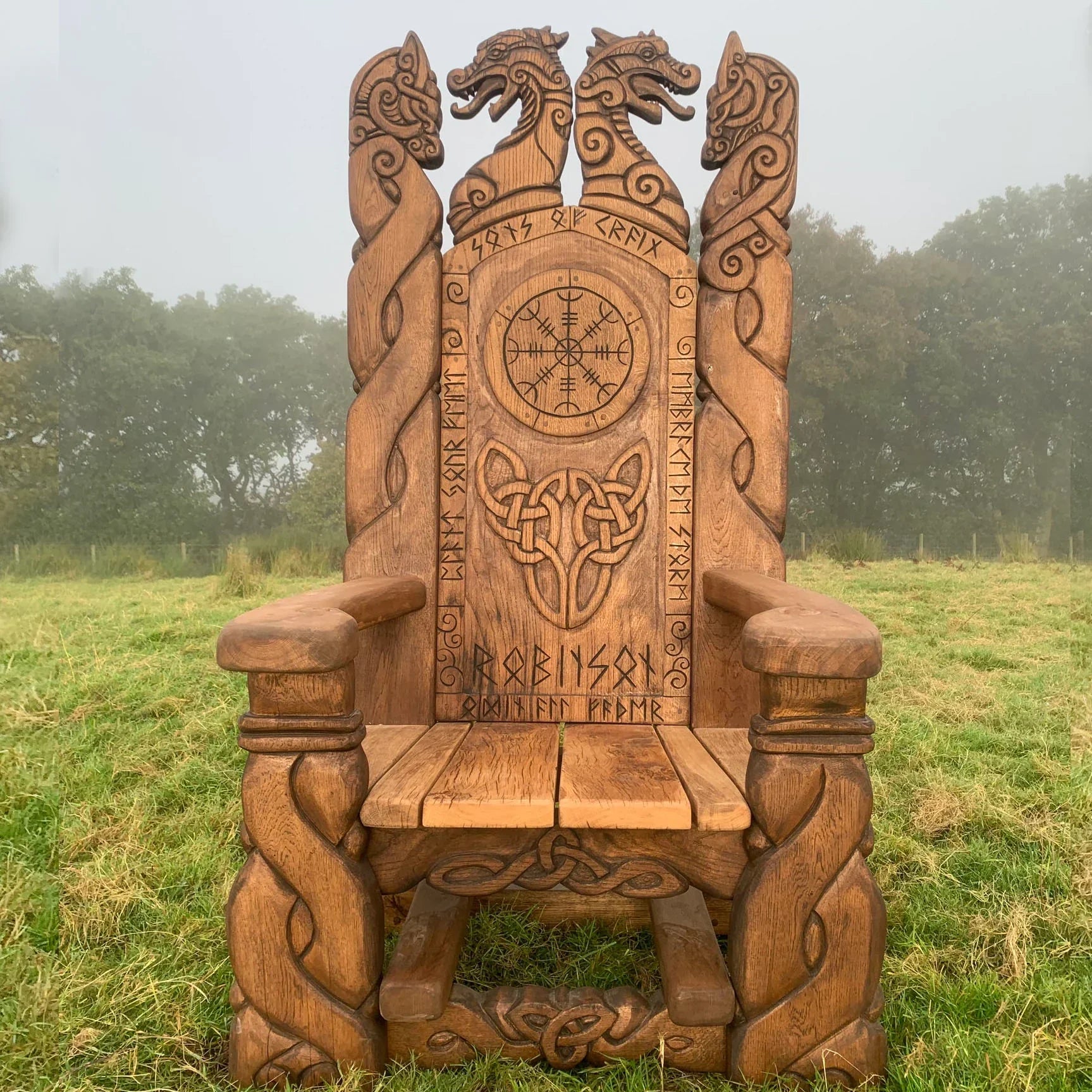 A wooden throne with intricate Celtic and Viking carvings, featuring dragon heads and knotwork designs.