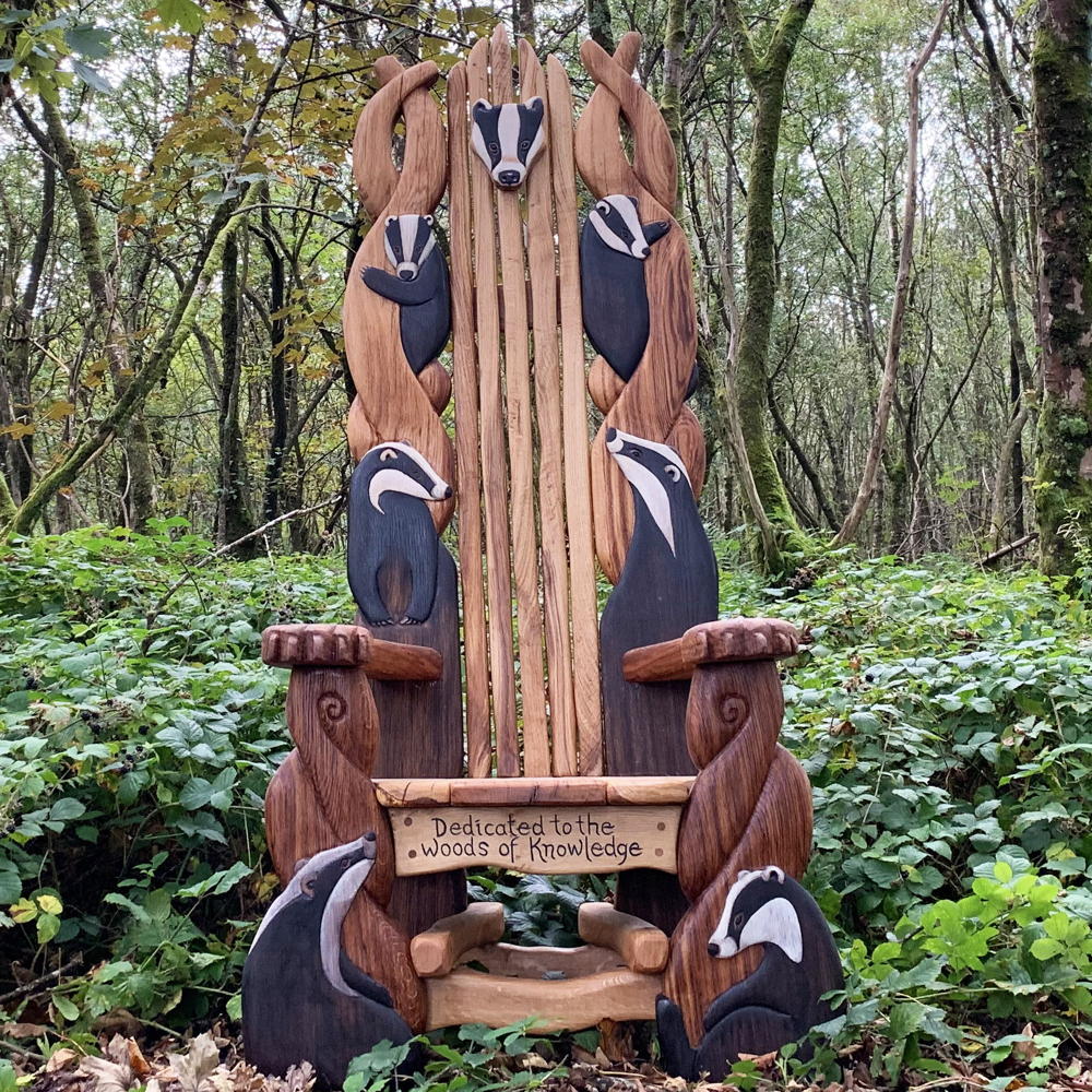 Handcrafted wooden storytelling throne chair with intricate badger carvings, made from solid oak, perfect for outdoor gardens and reading spaces