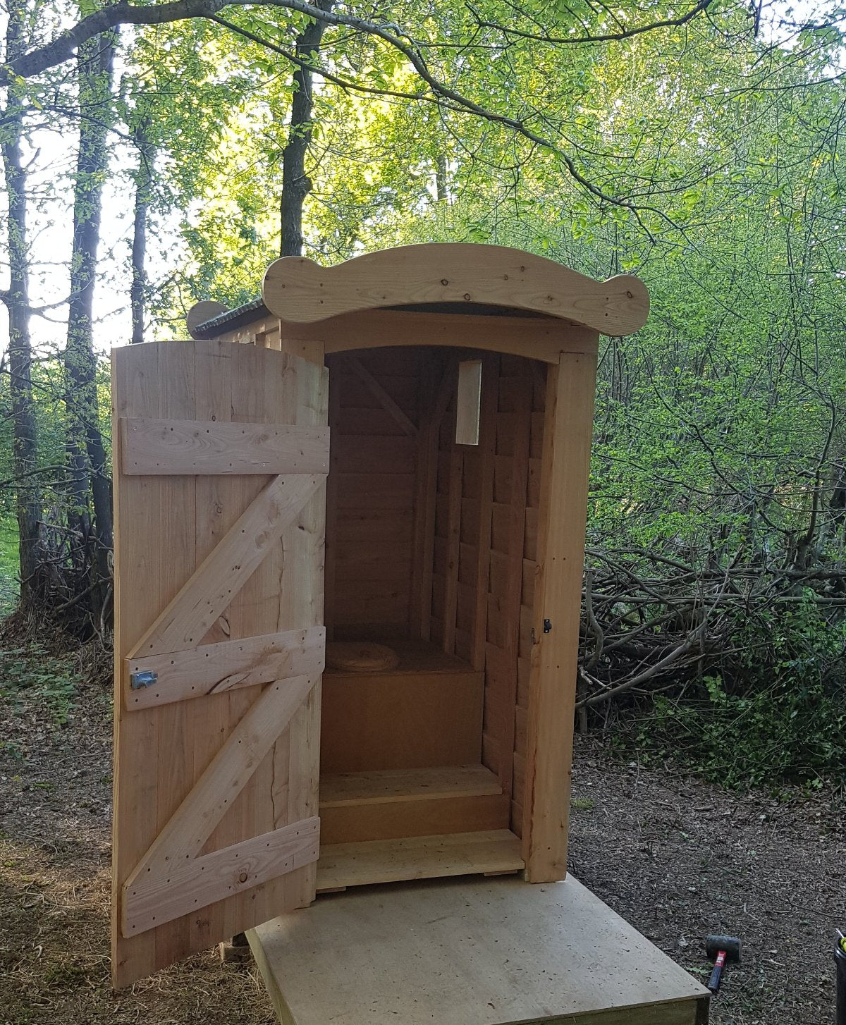 Wooden waterless toilet installed in woodland setting with cedar cladding