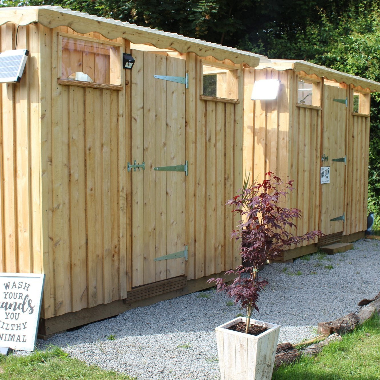 Wooden Dual Composting Toilet and Shower Unit with stylish cedar cladding and natural light design, ideal for campsites and glamping retreats