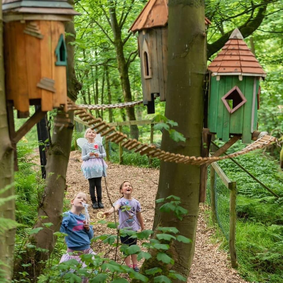 Family enjoying fairy tree houses in a forest