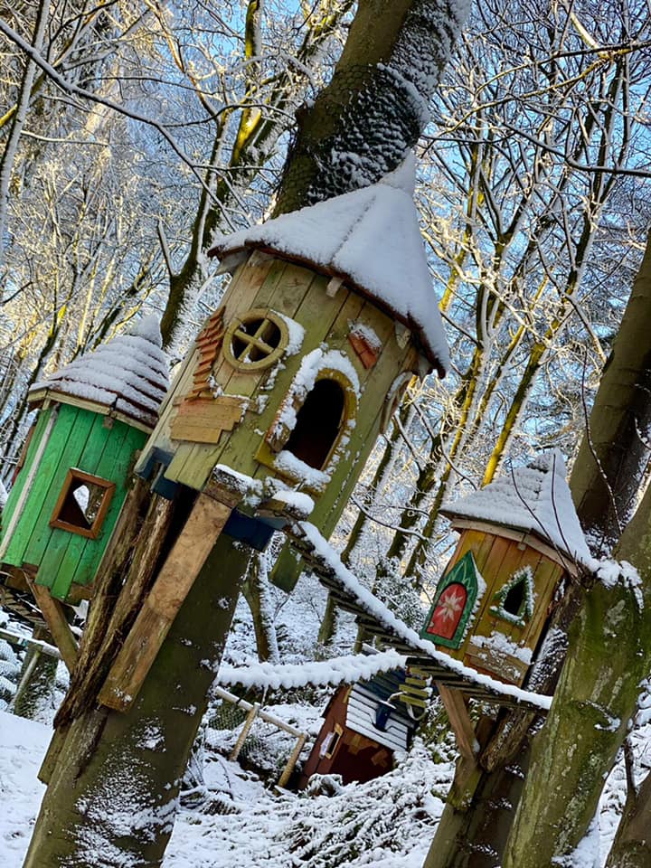 Verschneite Märchenbaumhäuser im Winterwald