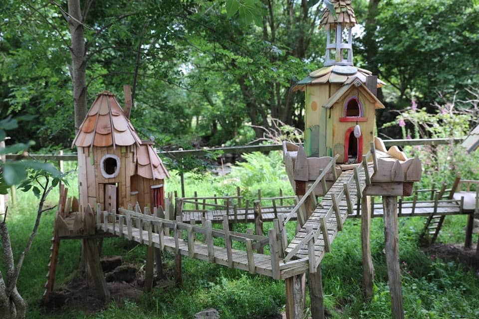 Fairy houses with bridges in a lush green setting