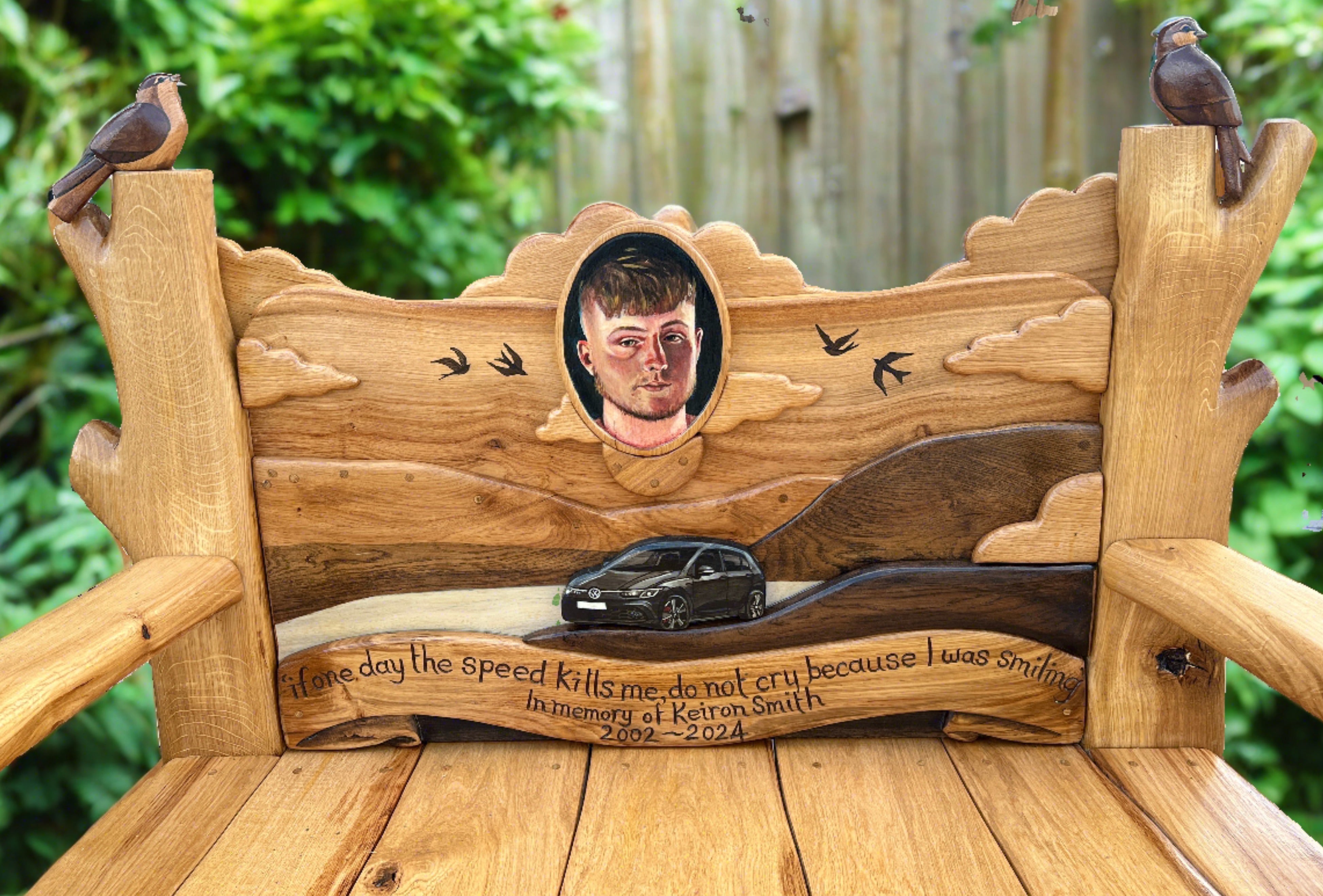 Close-up of engraved memorial bench with portrait and car design