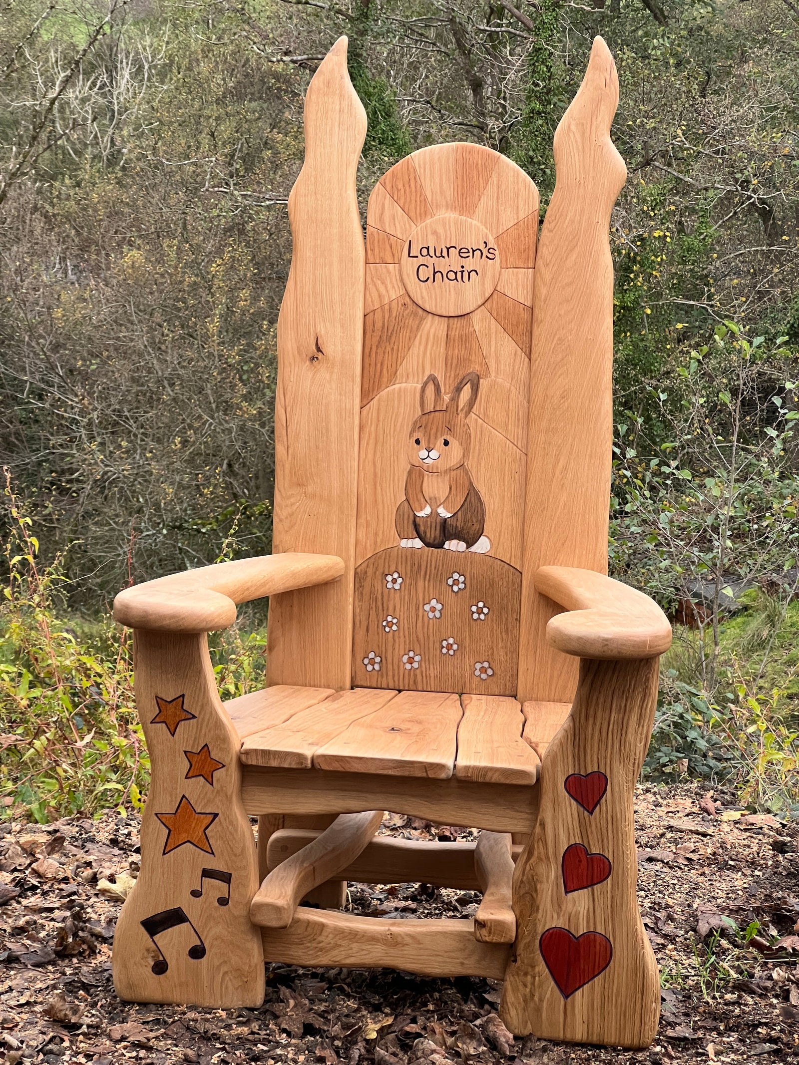 Carved oak bunny reading throne in school outdoor space — personalised storytelling chair, handmade in Wales