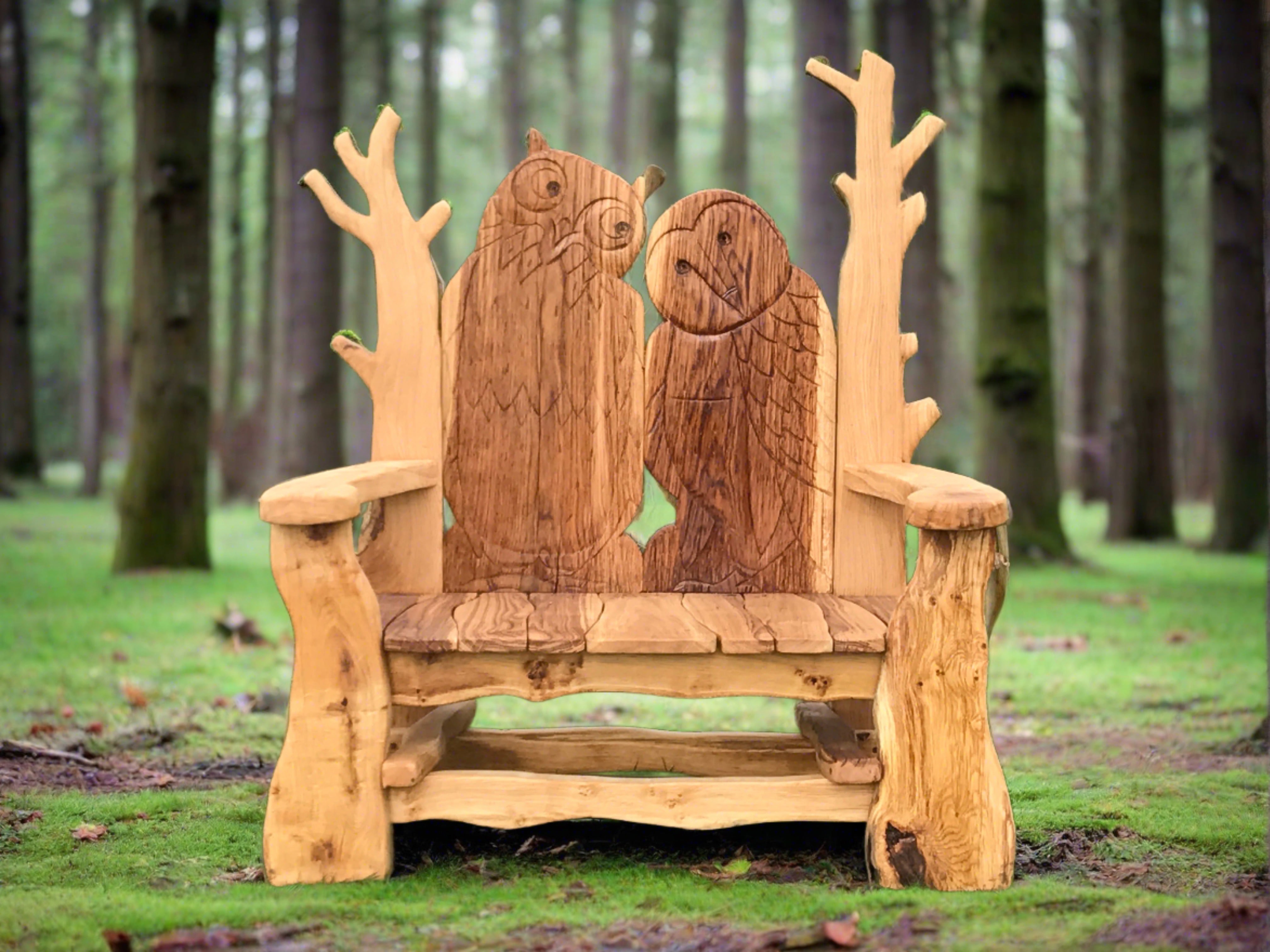 Wooden bench featuring carved owls in a forest setting.