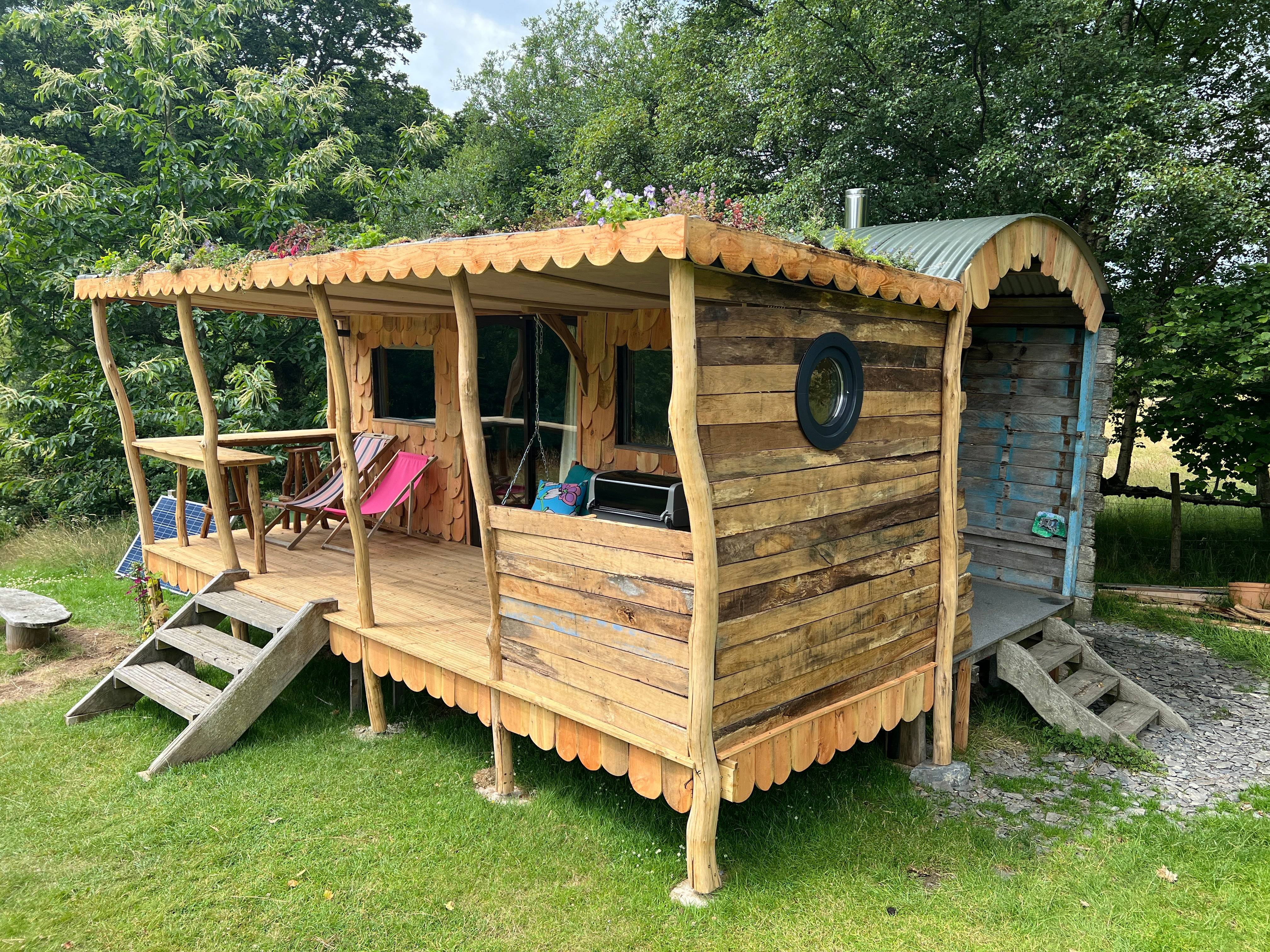 Hölzerne Hirtenhütte mit Veranda und Sitzgelegenheiten