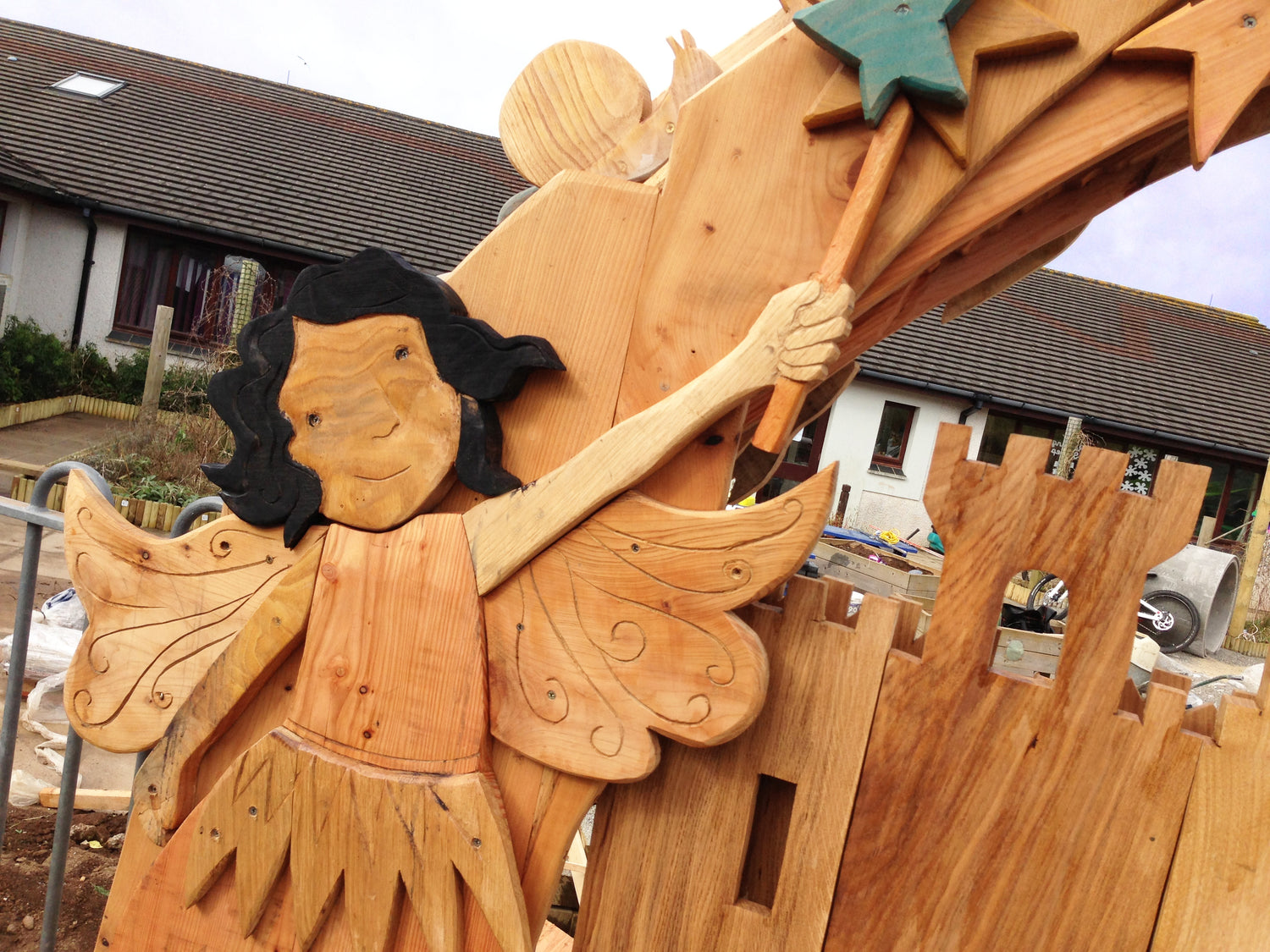 Wooden angel sculpture with a star on a wooden structure