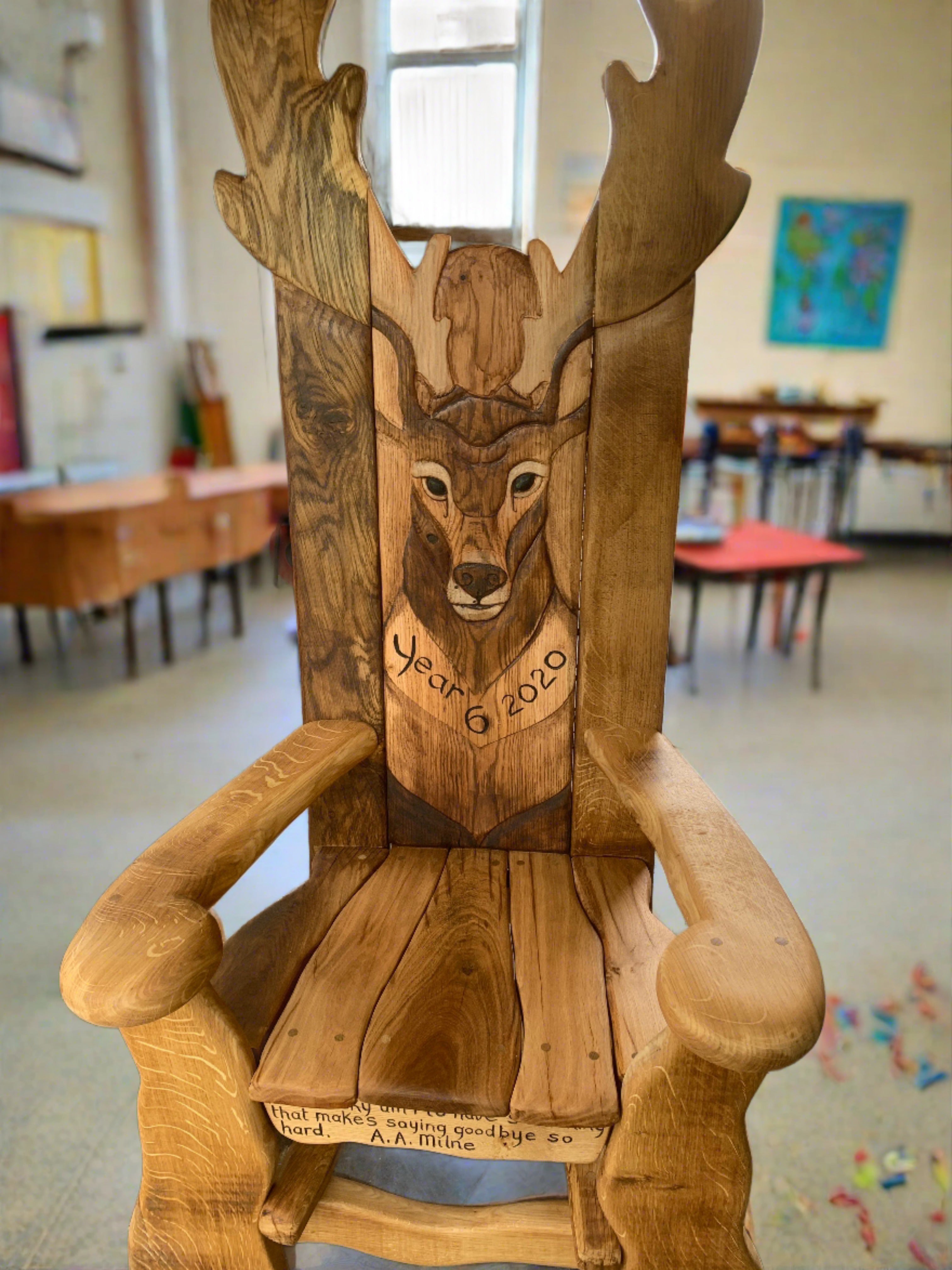 Chaise en bois avec sculpture de cerf dans une salle de classe.