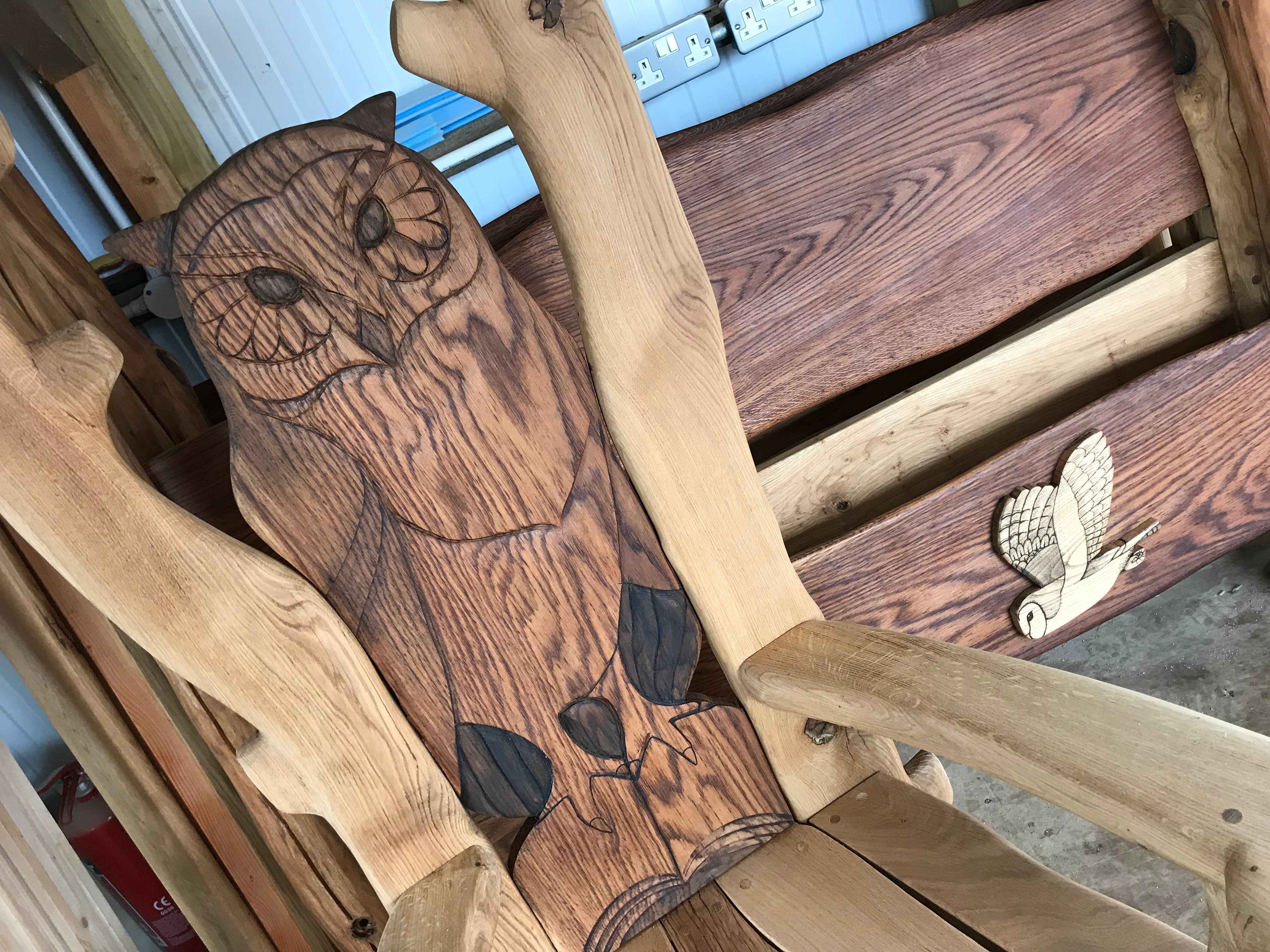 Hibou sculpté sur une chaise en bois dans un atelier.