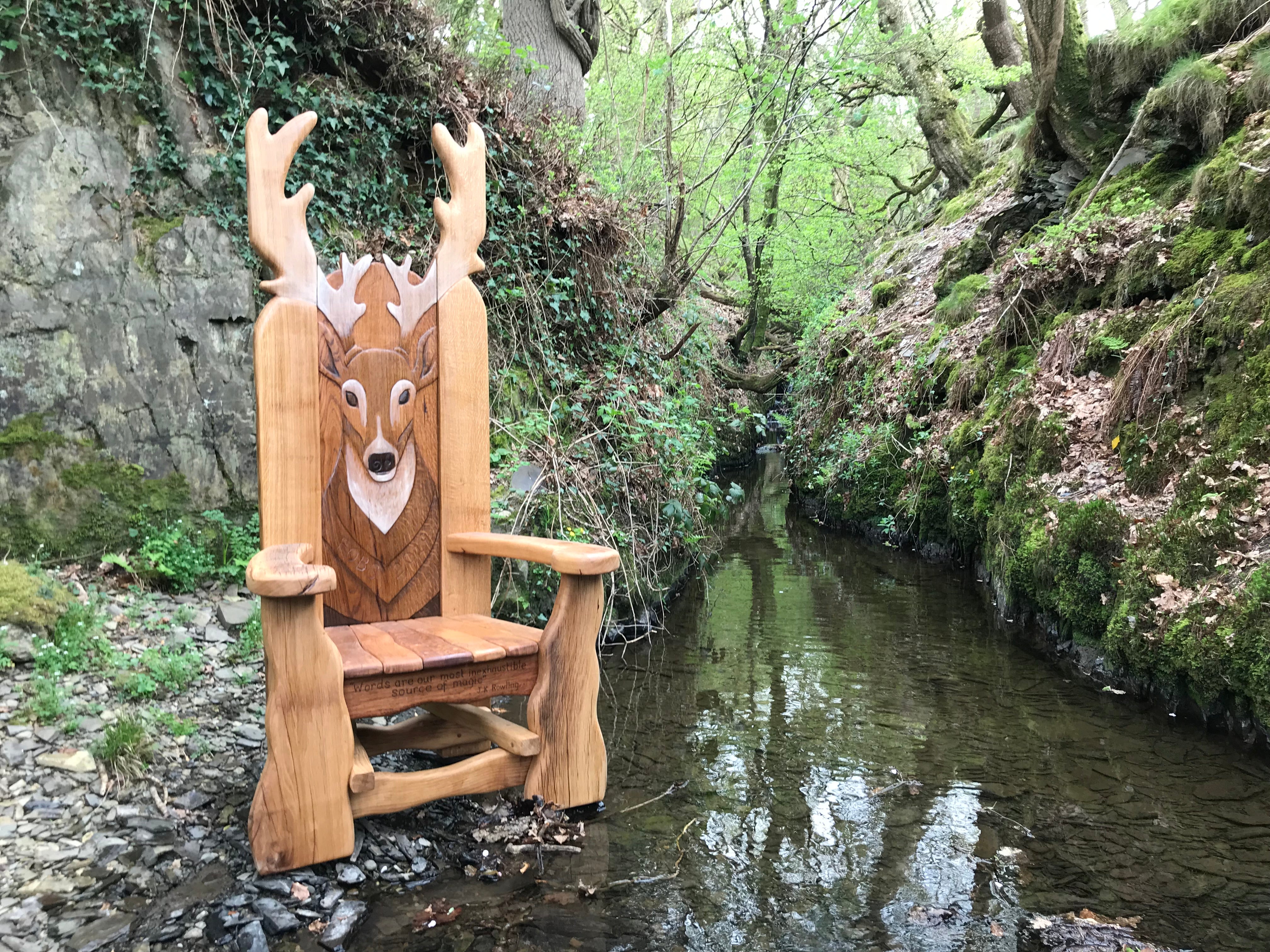 Chaise en bois sur le thème du cerf au bord d'un ruisseau de forêt.