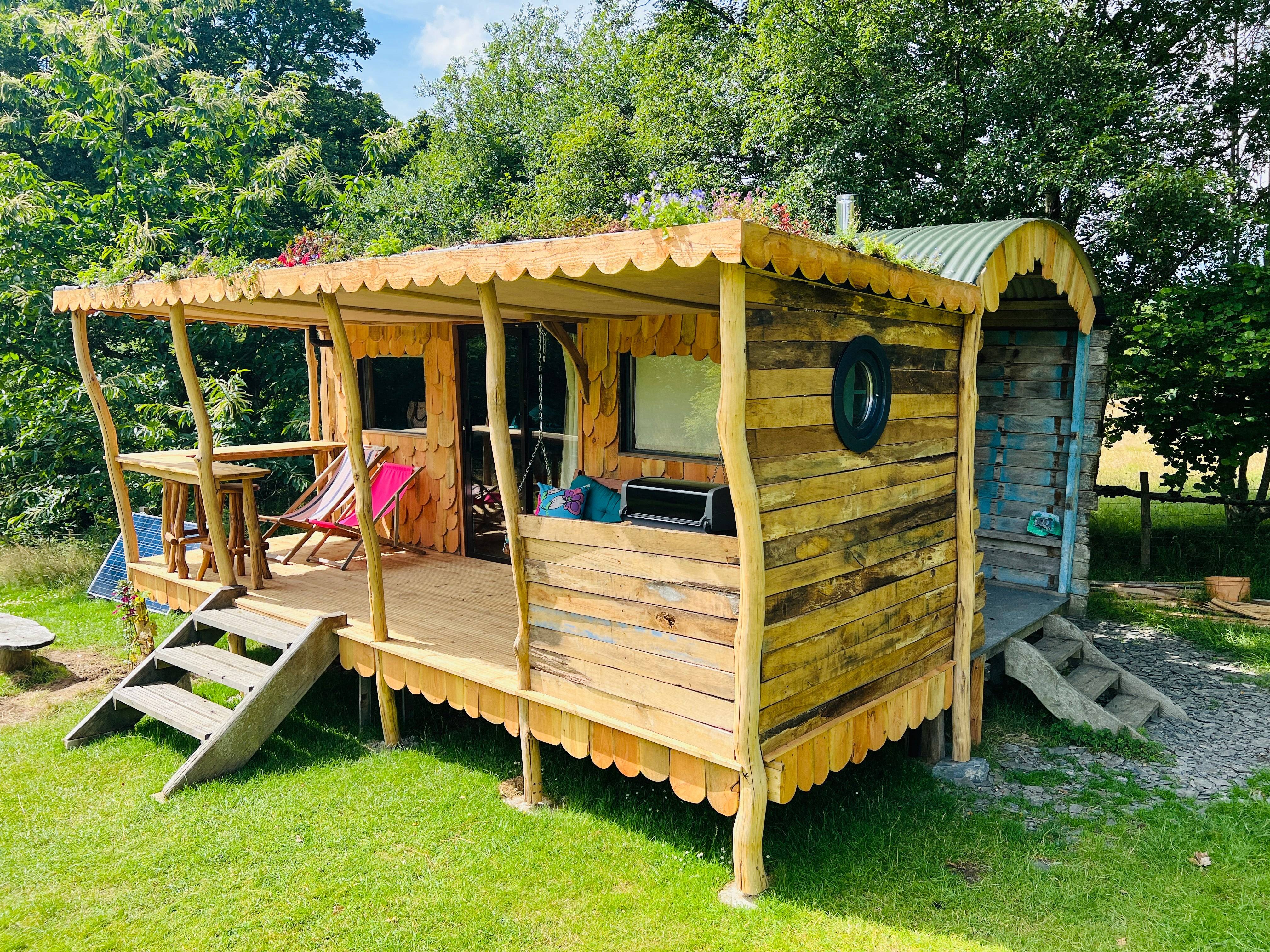 Wooden shepherd's hut exterior with porch and greenery