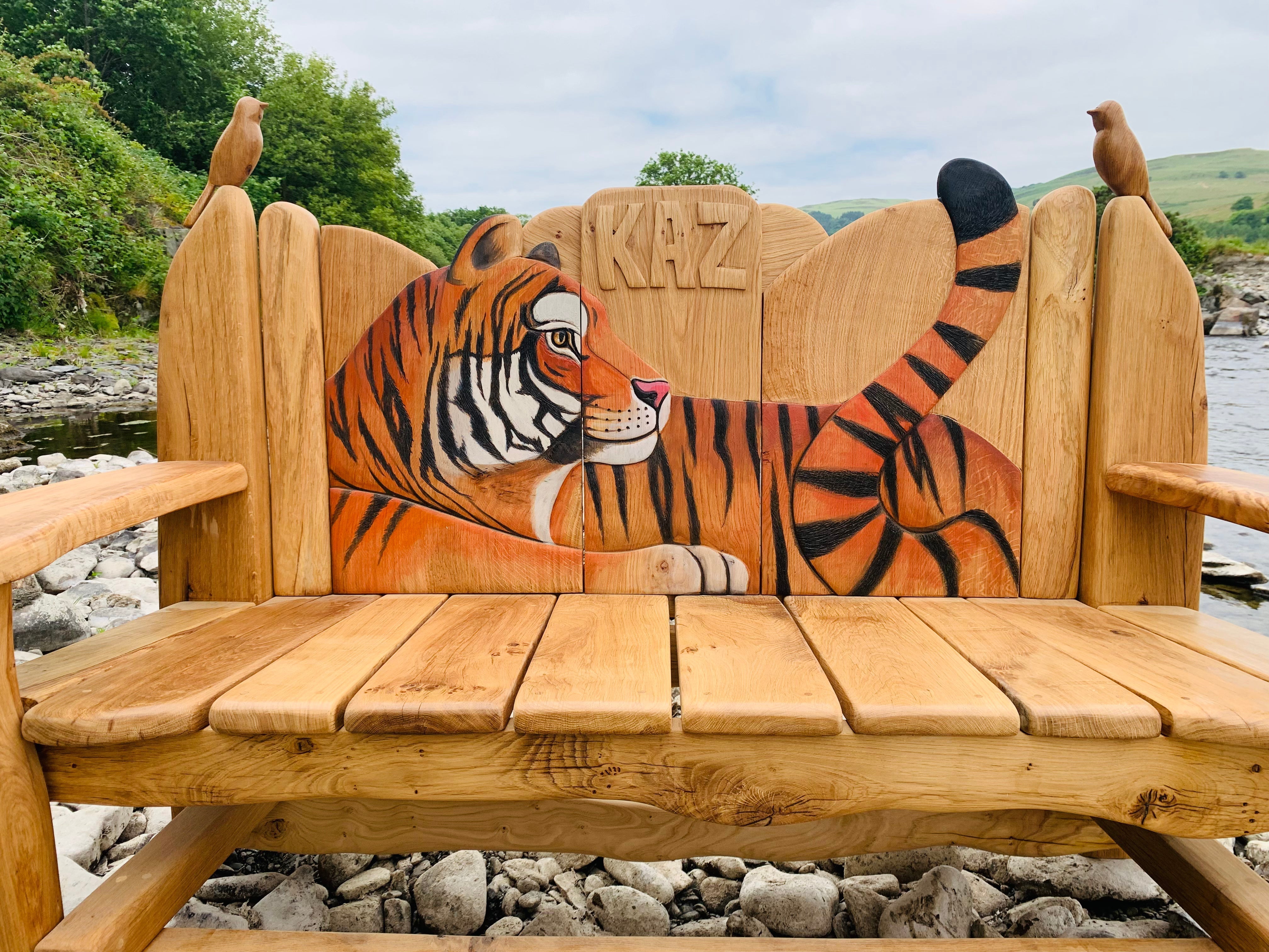 Banc en bois avec sculpture de tigre au bord de la rivière