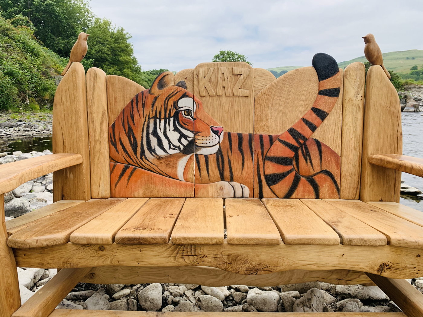 Wooden bench with carved tiger and personalized name.