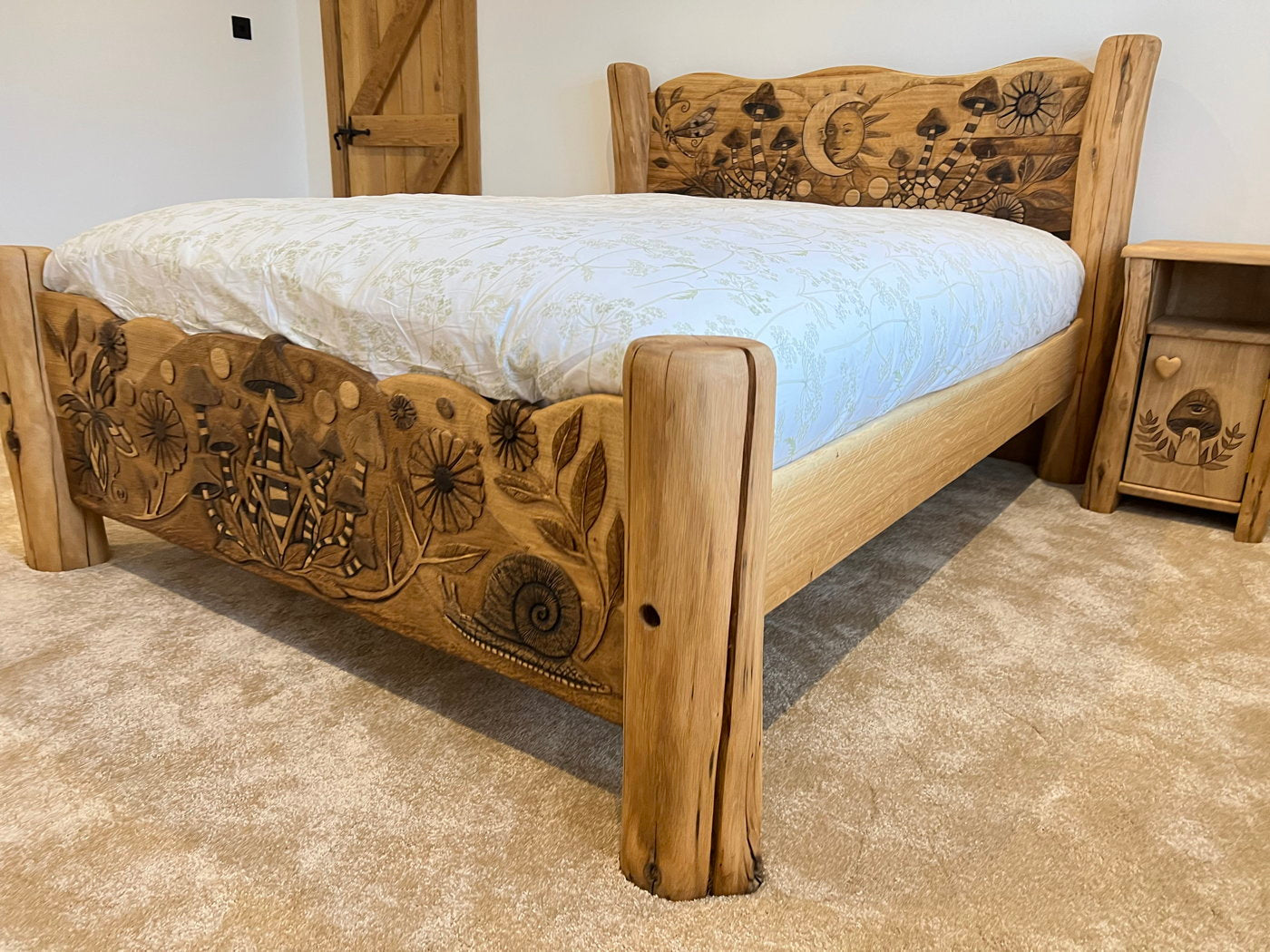 Side view of oak bed with carved designs in bedroom