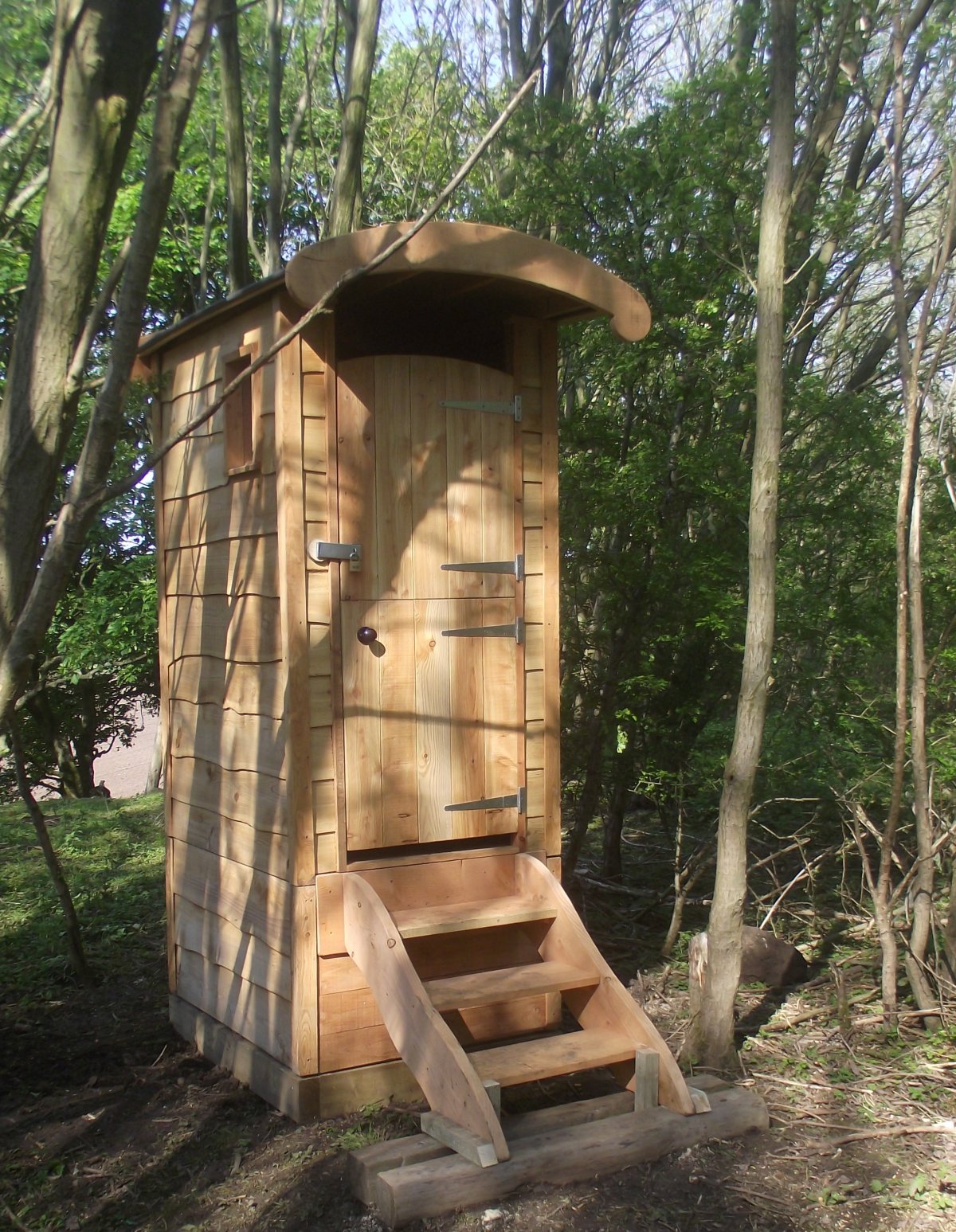 Eco-Compost Toilet in monastery church yard with trees in background