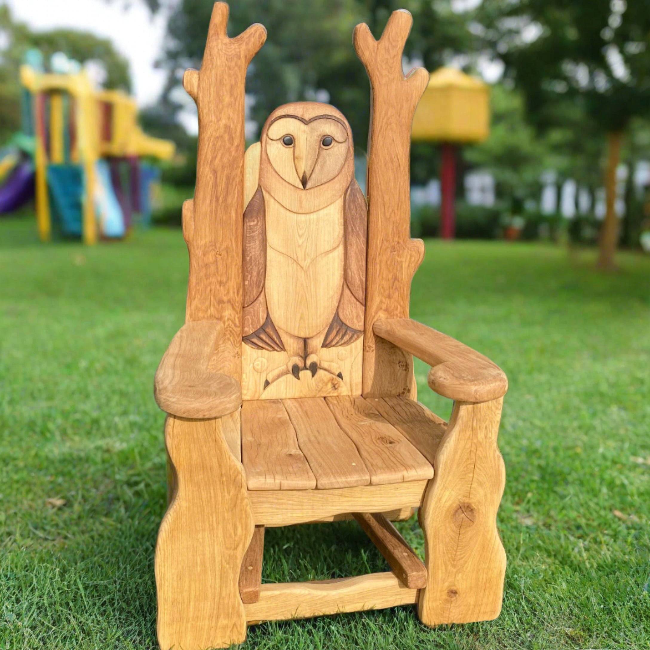 Carved oak owl reading chair on grass