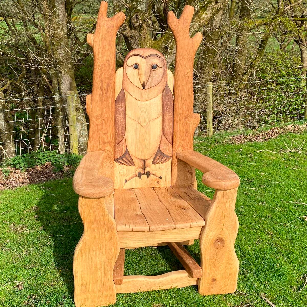 Chaise de lecture en forme de hibou sculpté sur de l'herbe verte