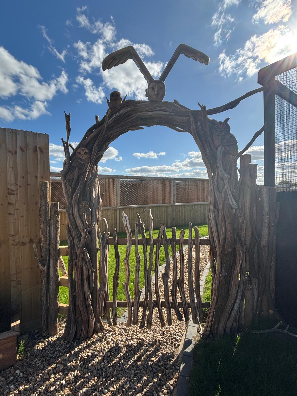 Oak Owl arch installed at an entrance with a rustic wooden gate 
