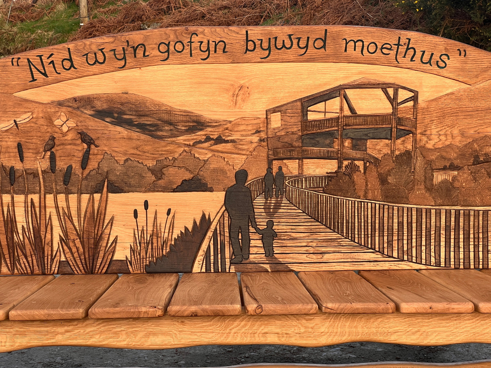 Full-length front view of the Ospreys Bench with osprey carvings framing the seating area
