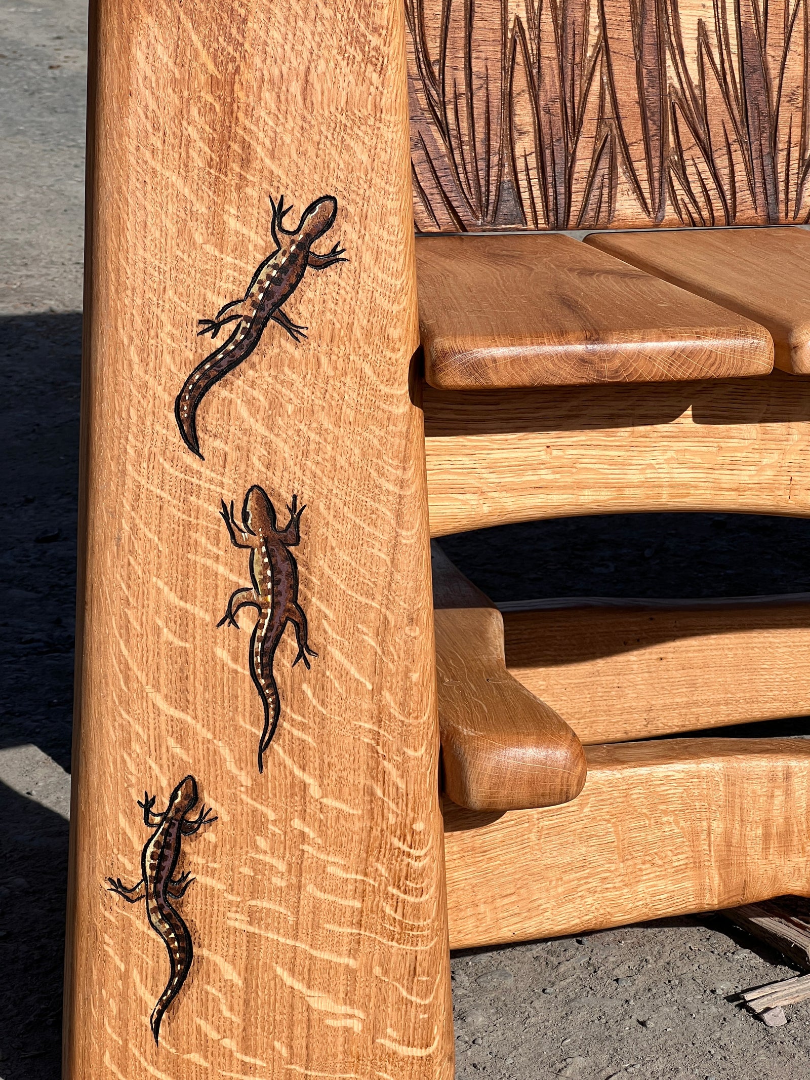 Detailed view of carved Welsh lettering and landscape scene on the bench back panel